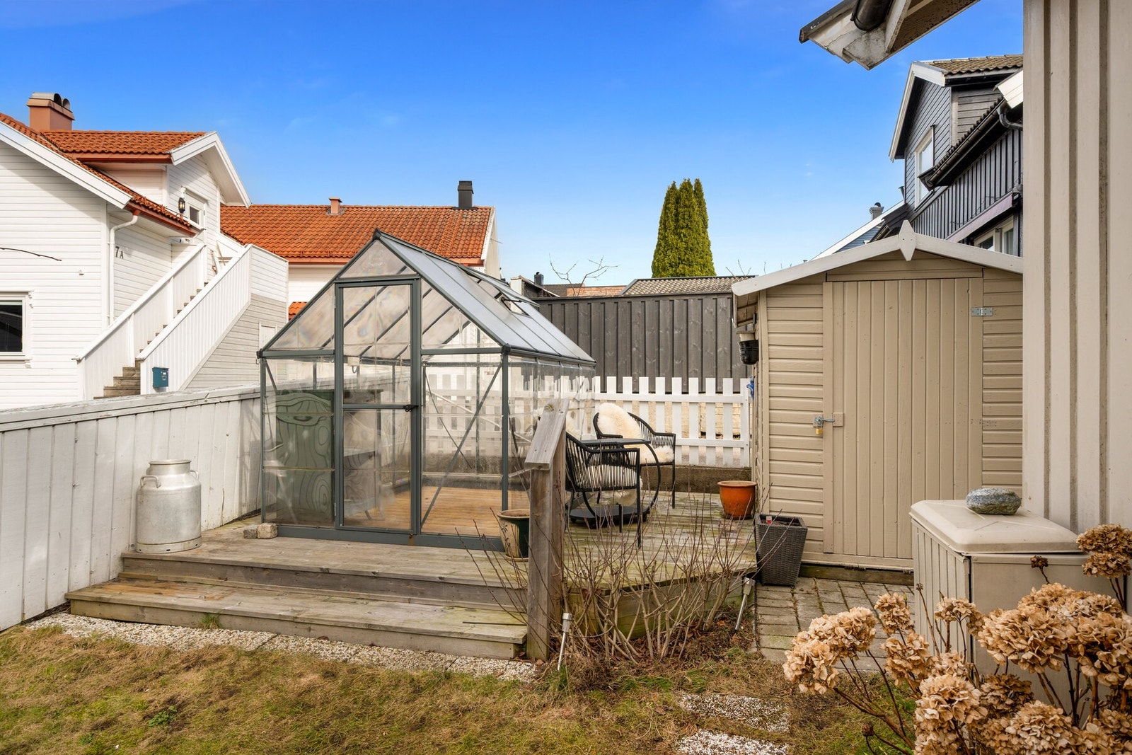 Fra terrassen går det trapp ned til en lettstelt hage, en ekstra terrasse med drivhus og en praktisk utebod. Et perfekt sted for både grønne fingre og avslappende stunder. Galleribilde