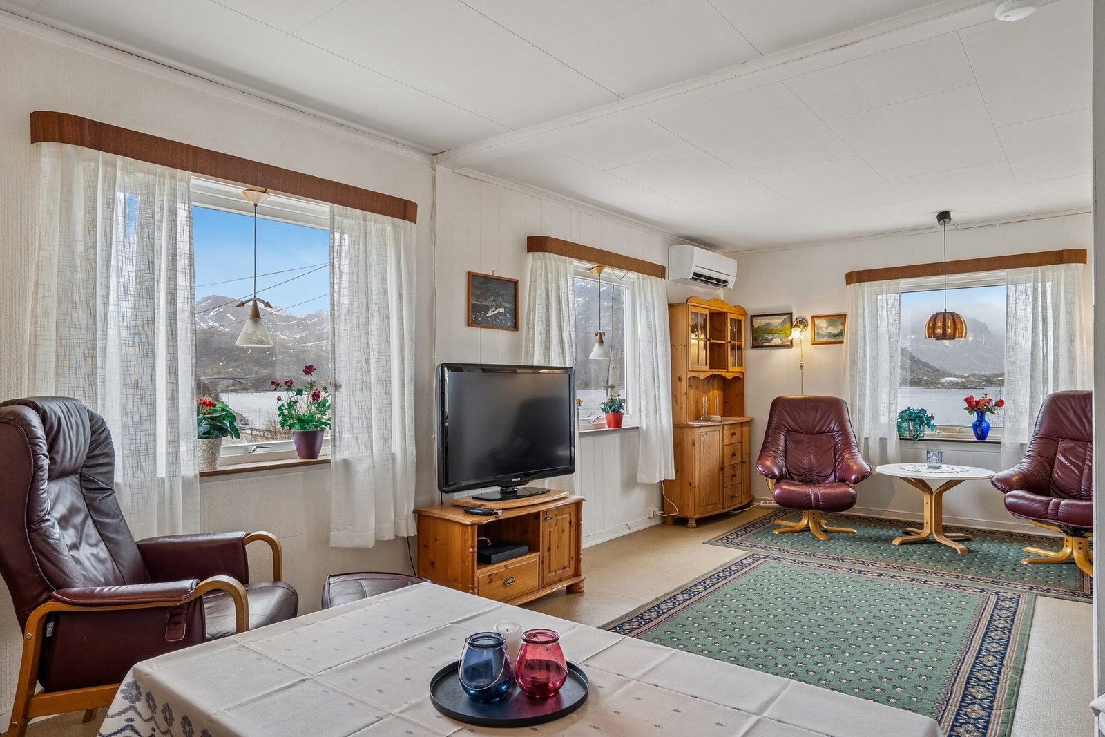 Lys stue med store vinduer som slipper inn både rikelig med dagslys, men gir også en fin utsikt ut mot vannet og naturen. Galleribilde