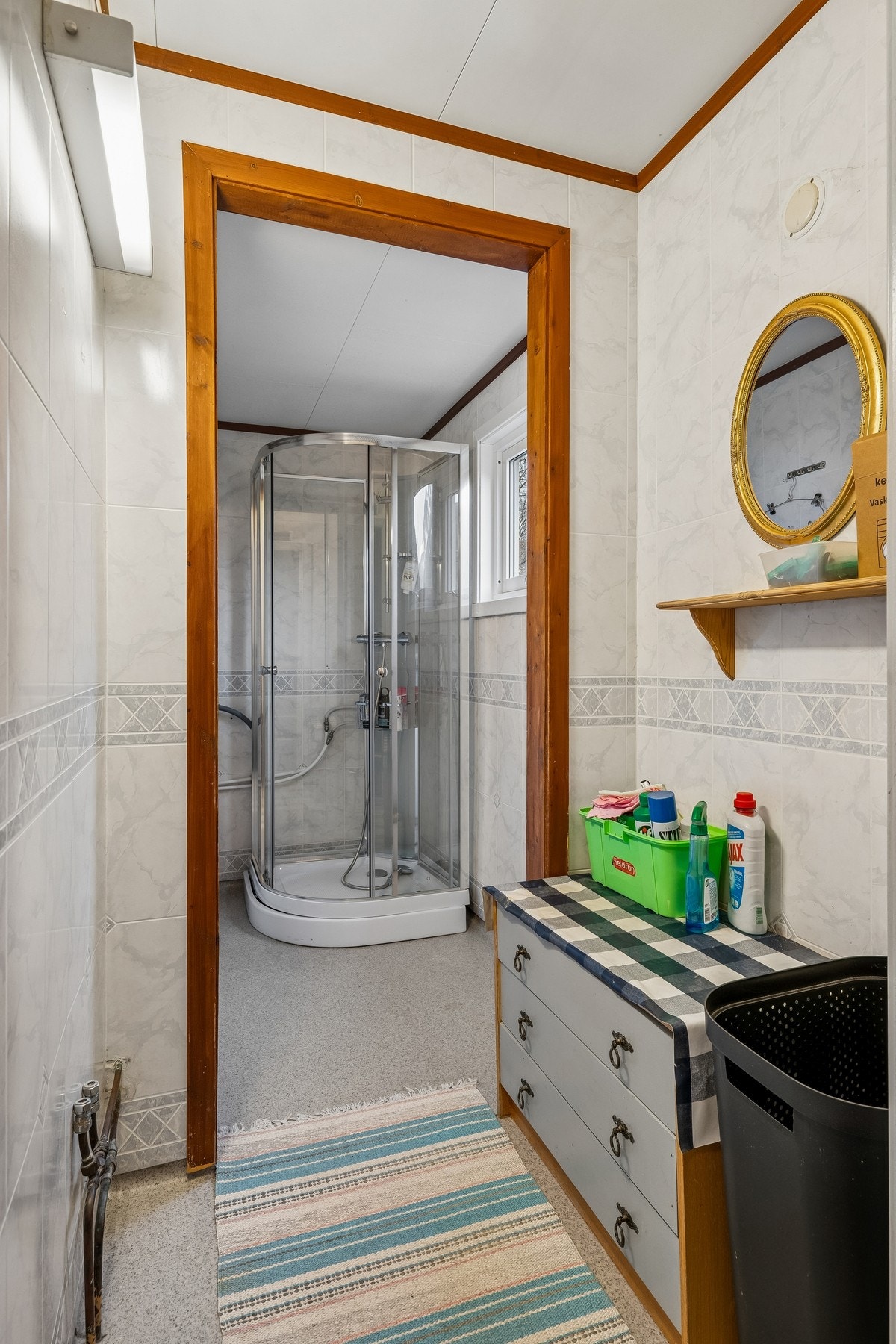 Bad/vaskerom hvor det er dusjkabinett og opplegg for vaskemaskin. Galleribilde