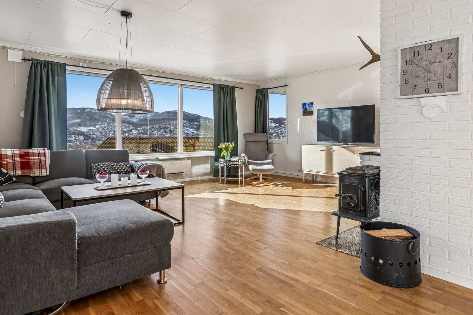 Lys og romslig stue med store vinduer som slipper inn rikelig med dagslys Galleribilde