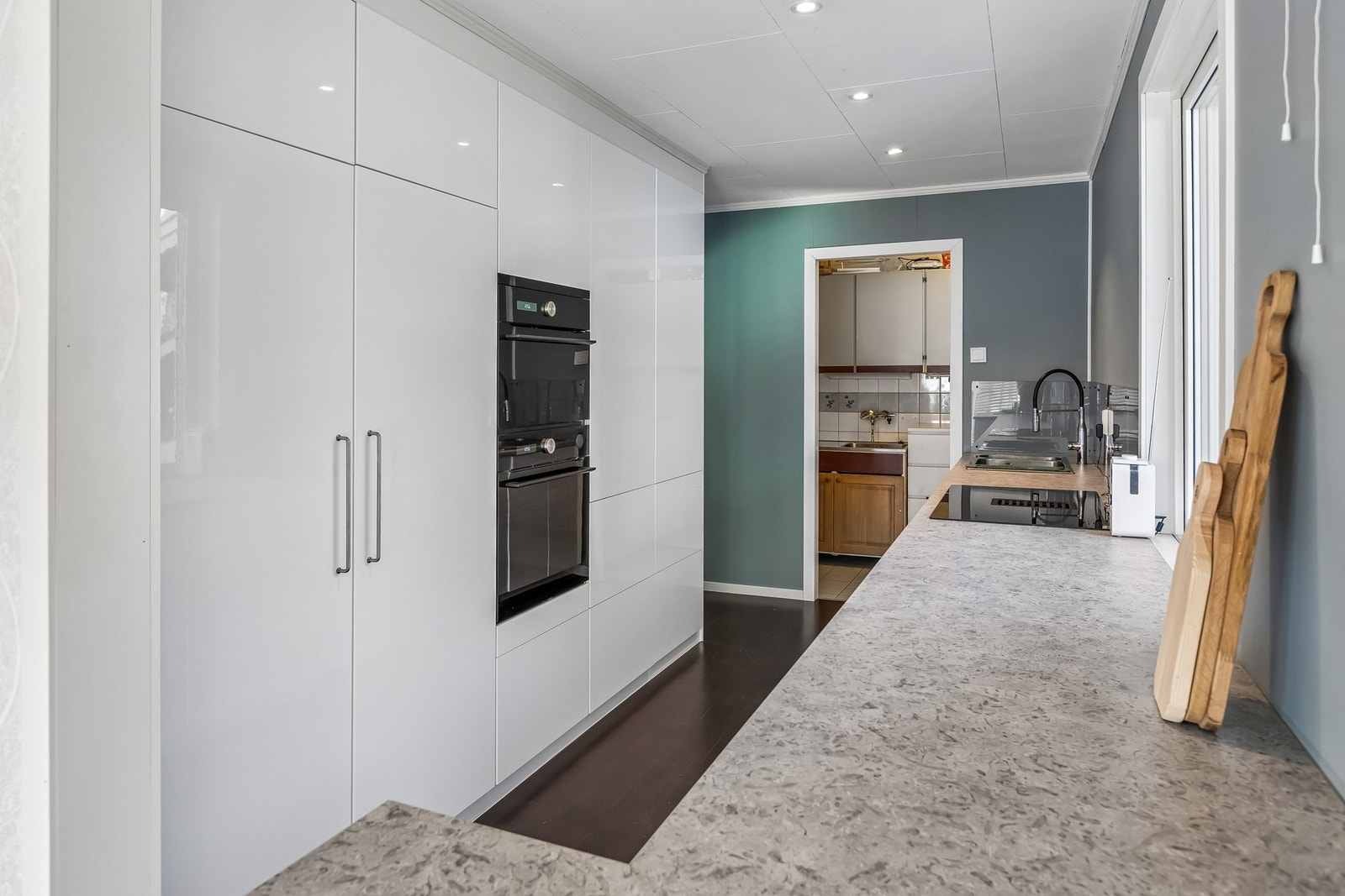 Praktisk arbeidsområde med laminatbenkeplate og integrerte hvitevarer Galleribilde