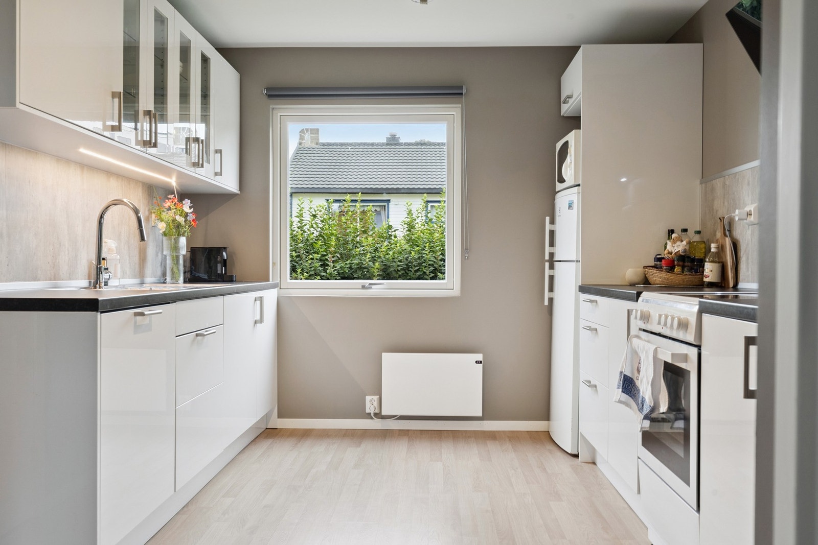 Moderne kjøkken med glatte fronter og laminat benkeplate. Galleribilde