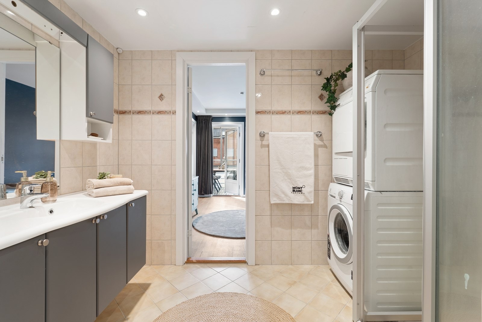 Romslig flislagt bad med opplegg for vaskemaskin Galleribilde