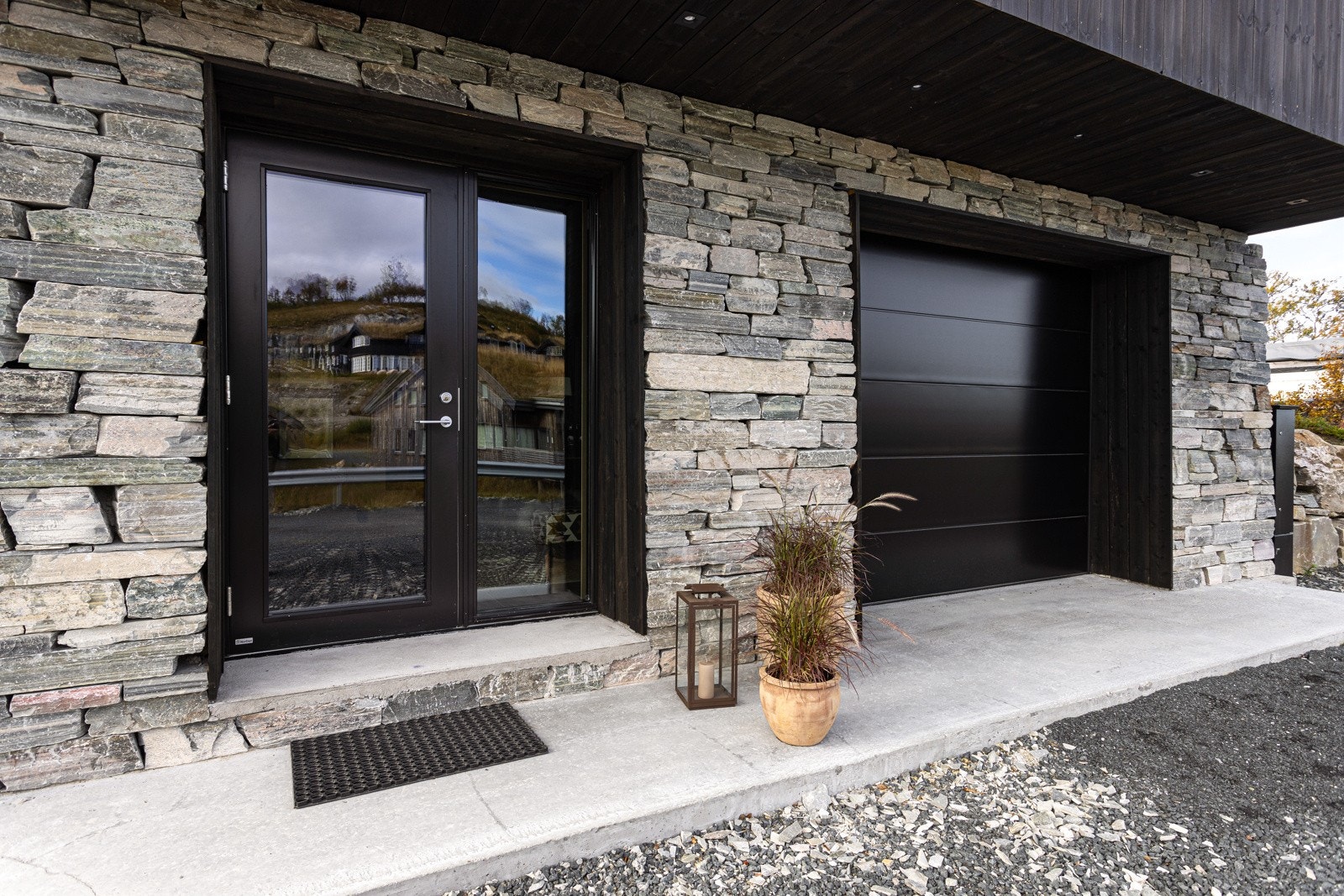 Innbydende inngangsparti. Her kan man også kjøre rett inn i garasjen og gå tørrskodd videre inn i hytta Galleribilde