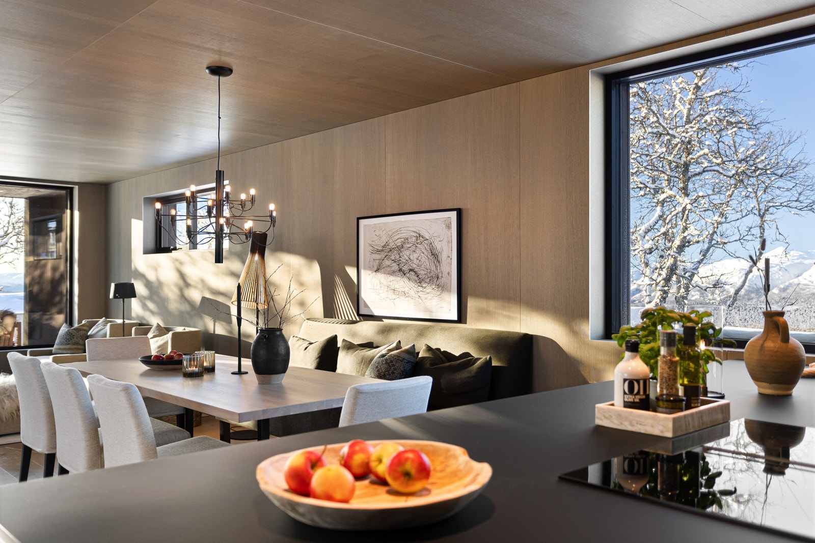 Praktisk og innbydende kjøkkenøy hvor man kan lage mat mens man deltar i samtalene med gjester/familien rundt spisebordet Galleribilde