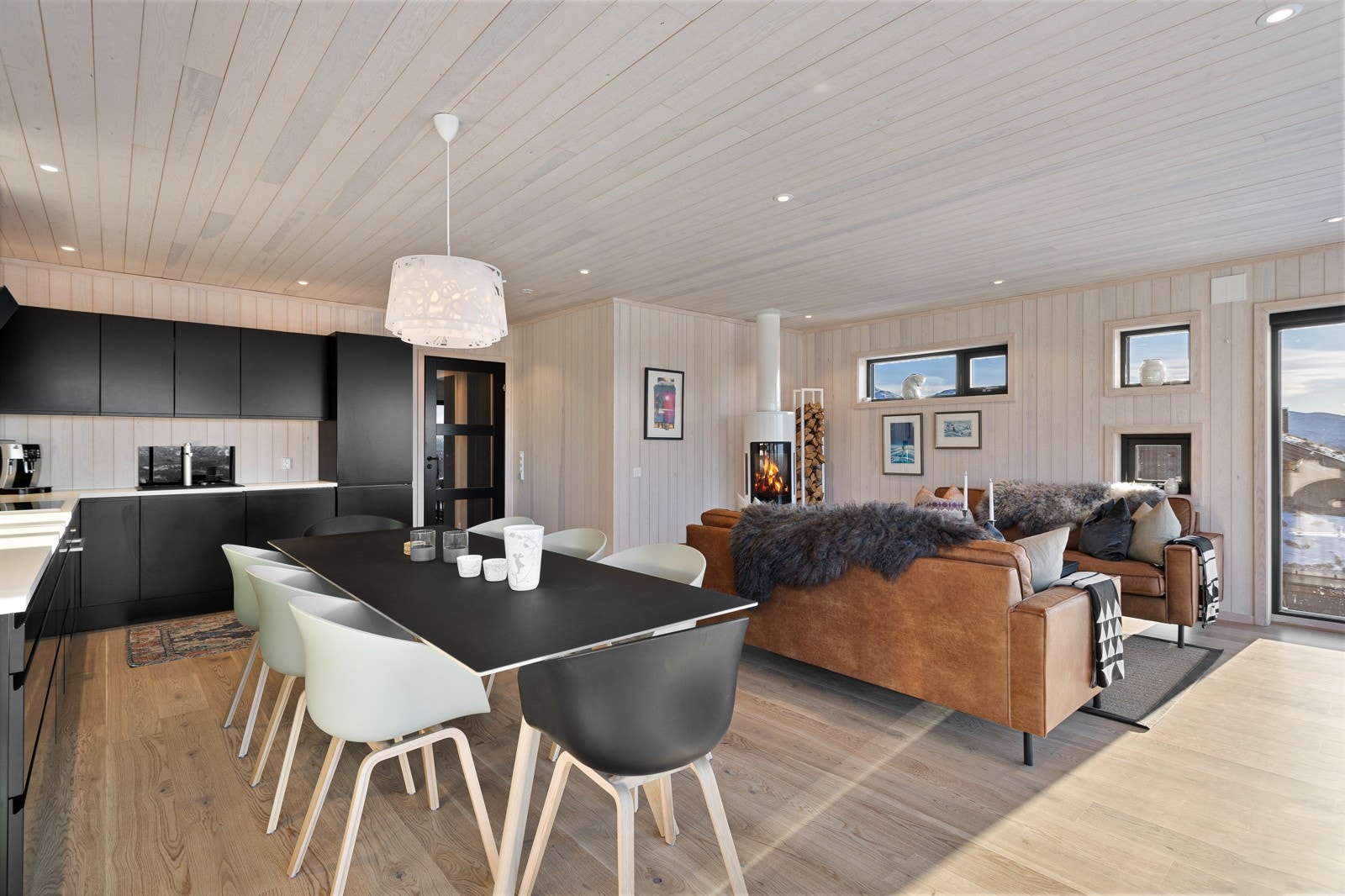 Stue/kjøkken, hvor man fra begge soner kan nyte synet av flammene som flakker i peisen Galleribilde