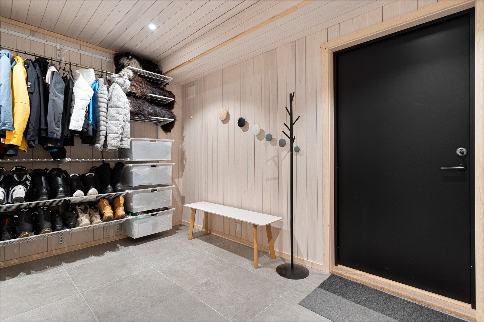 Velkommen inn! Man ankommer hytta via en pen, flislagt gang med varmekabler i gulv og downlights i himlingen. I hallen er det knagger med plass til oppbevaring av klær og sko. Galleribilde