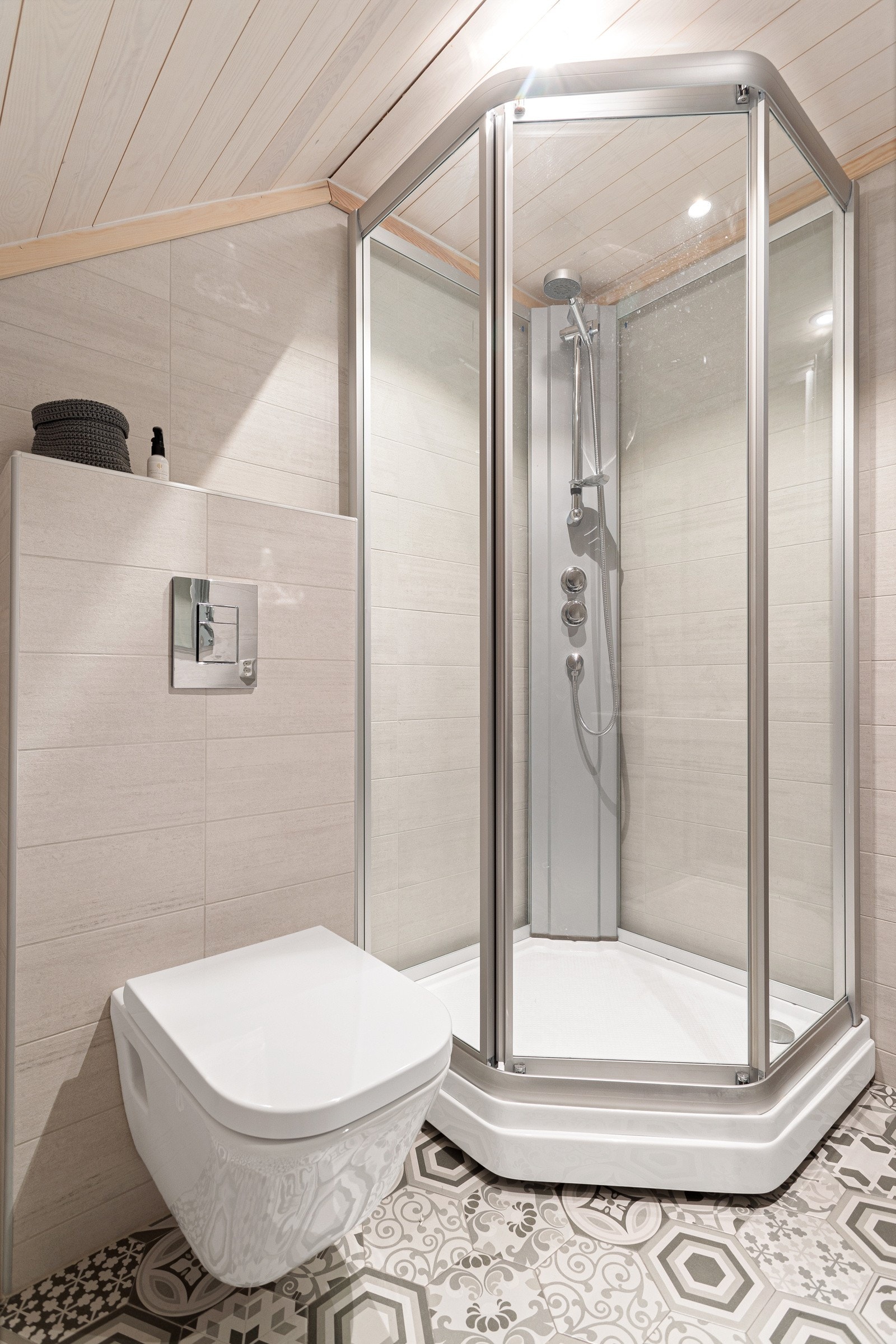 Badet har hel servantplate over skuffeinnredning, speil med integrert lys, dusjkabinett og vegghengt toalett. Galleribilde