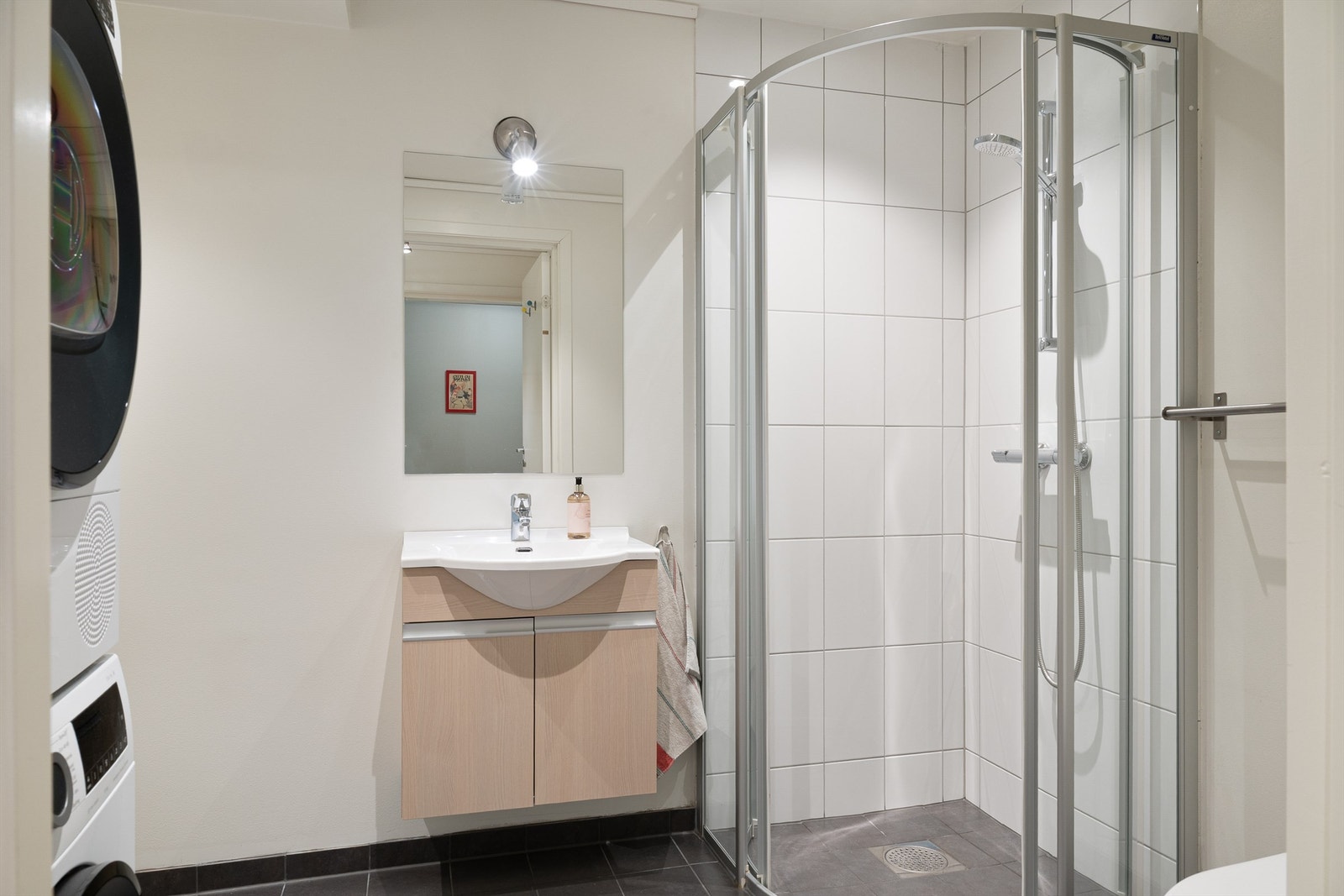 Innredet med dusjnisje, vask, wc og opplegg til vaskemaskin og kondenstørketrommel. Stor bod på innsiden av badet. Galleribilde