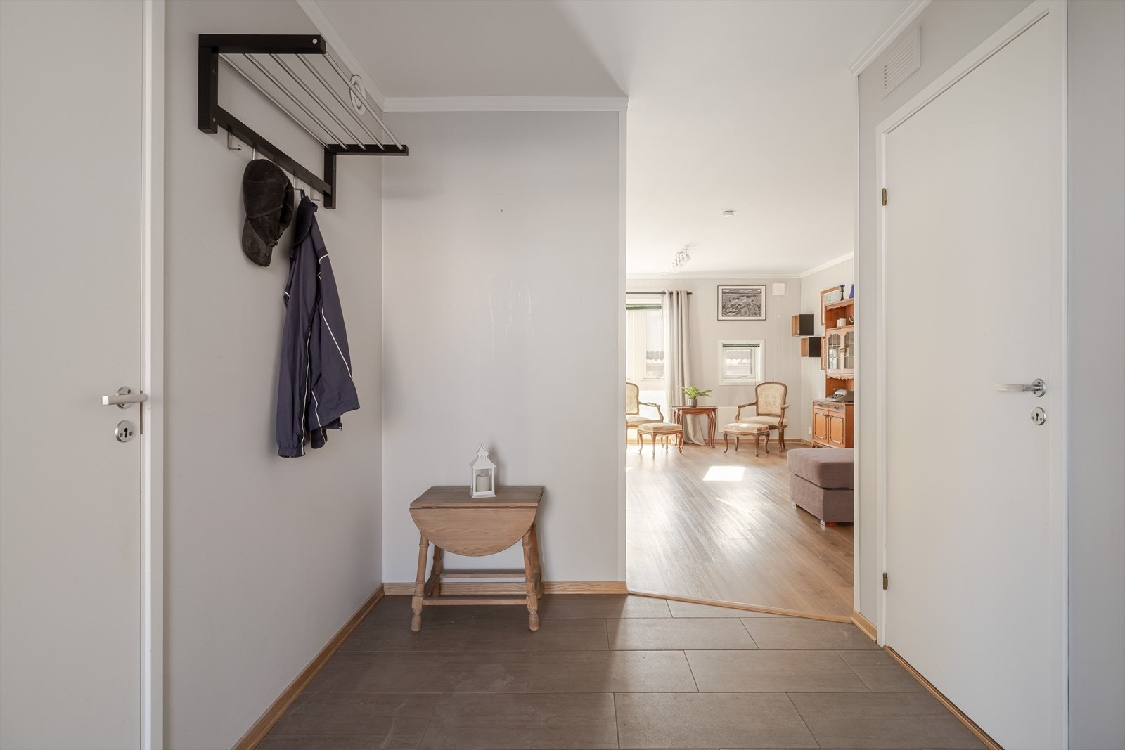 Romslig entré med flislagt gulv og god plass til oppbevaring av sko og yttertøy. Galleribilde