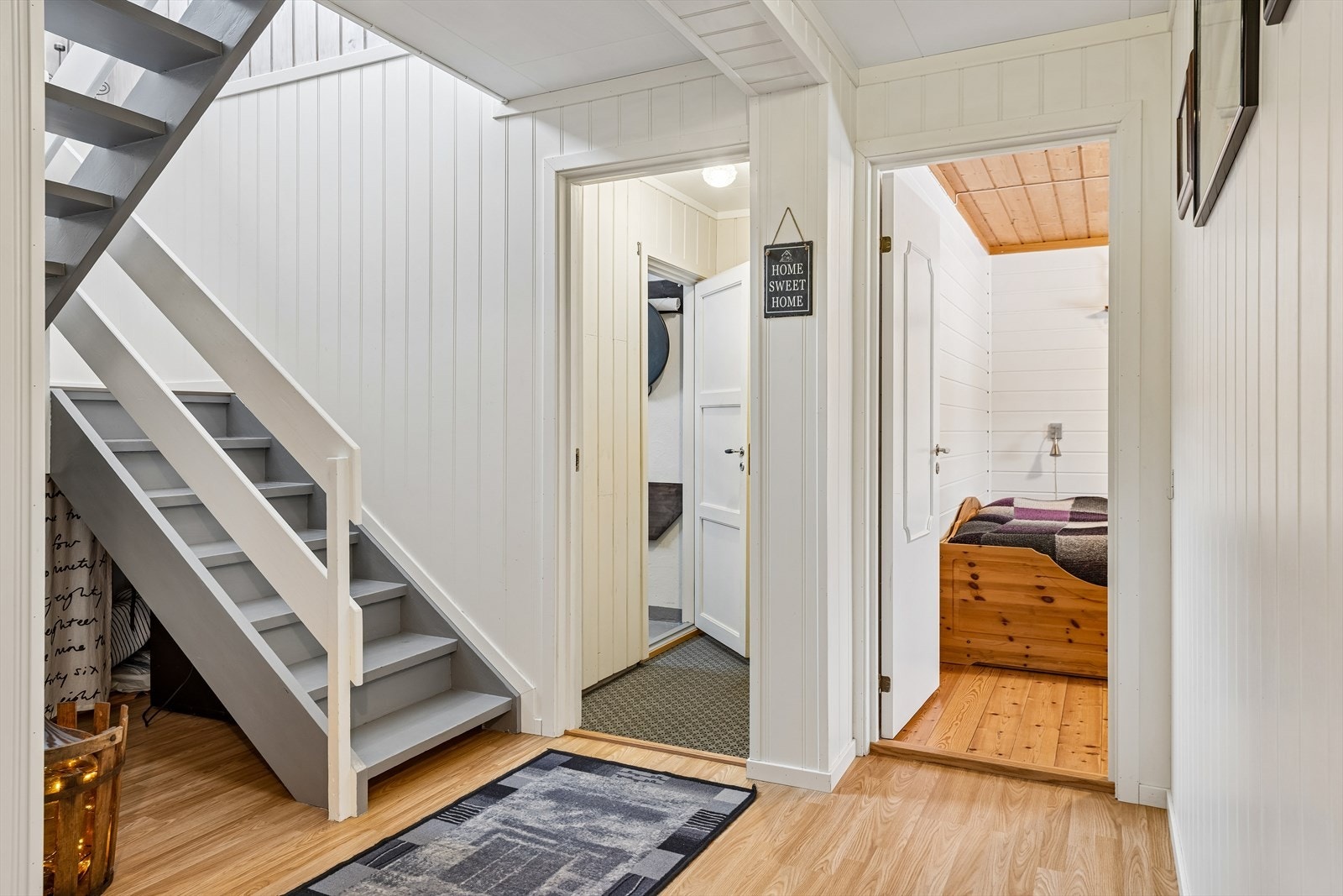 Innvendig malt tretrapp med åpne opptrinn forbinder de to etasjene. Galleribilde