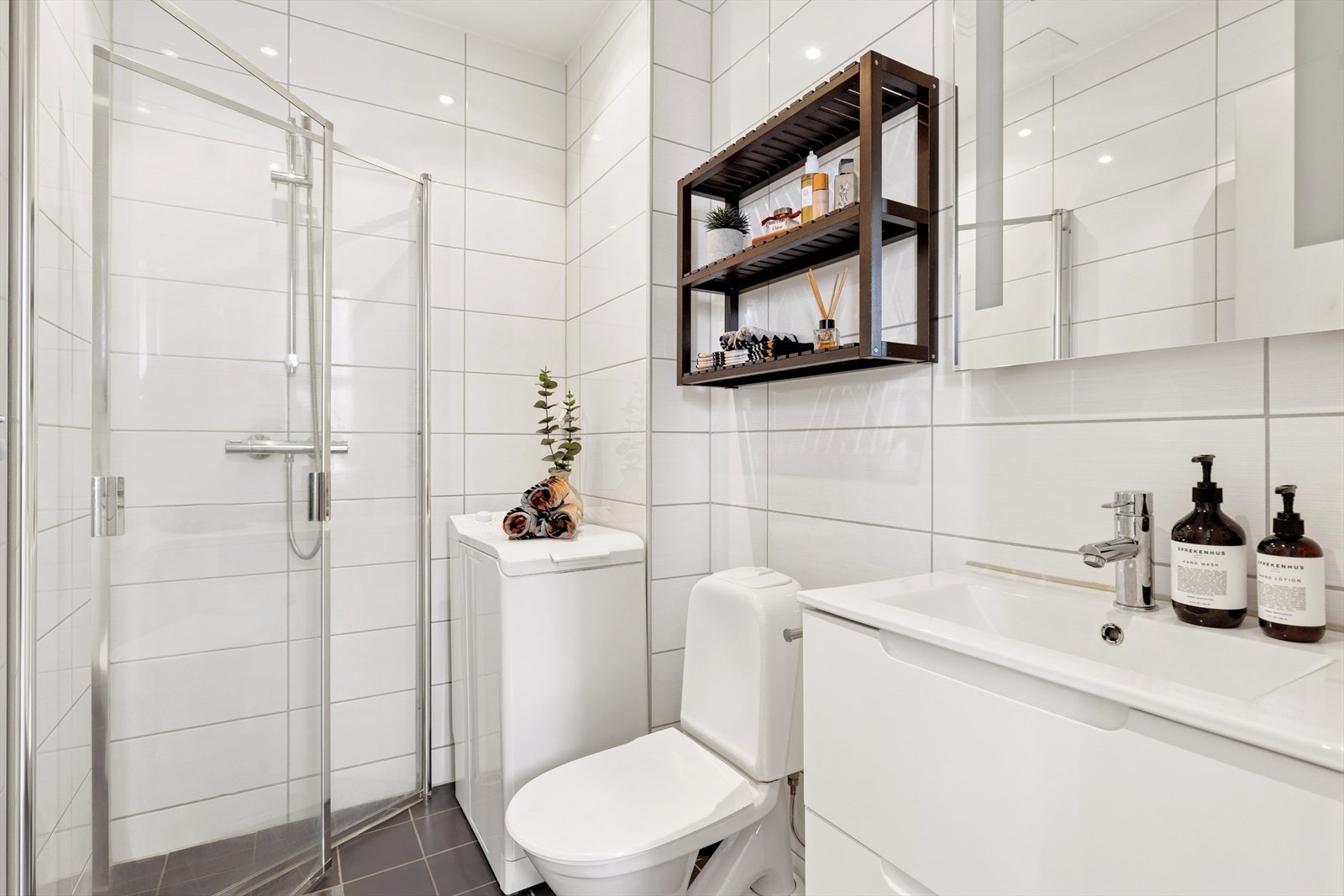 Gulvet er flislagt og utstyrt med elektriske varmekabler som gir god komfort. Badet er innredet med servant i moderne baderomsinnredning, toalett og dusjhjørne med dusjvegger. I tillegg er det opplegg for vaskemaskin. Galleribilde