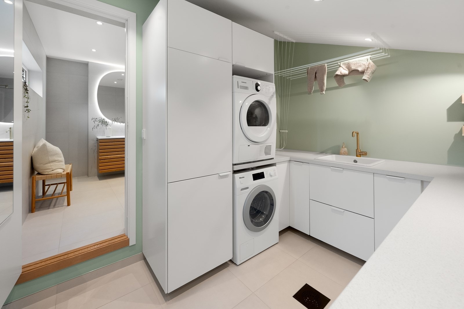 Praktisk og adskilt vaskerom med gode oppbevaringsmuligheter. Det er innredet med skapreoler og laminert benkeplate med nedfelt utslagskum i porselen. Opplegg for vaskemaskin. Varmekabler i gulvet for en behagelig temperatur. Galleribilde