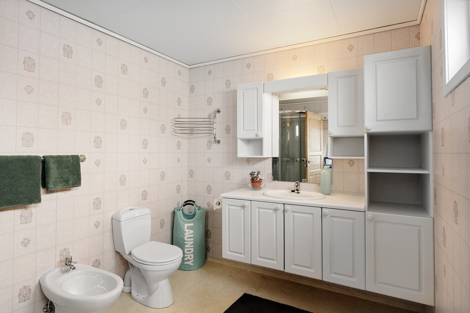 Badet har gulvvarme og er innredet med wc, dusjkabinett og seksjon med vask Galleribilde