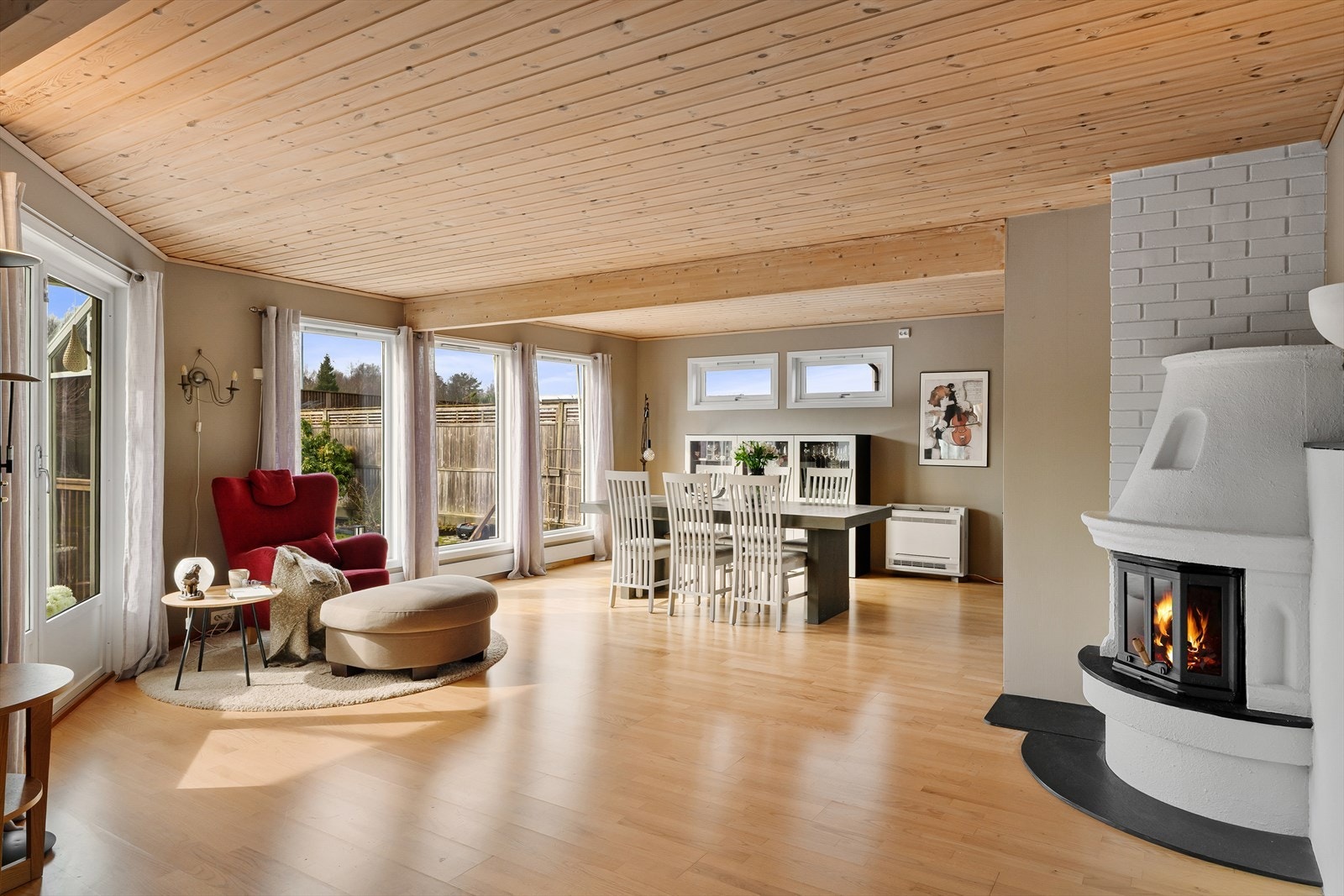 Lys og fin stue i vinkel med god plass til flere sittegrupper Galleribilde