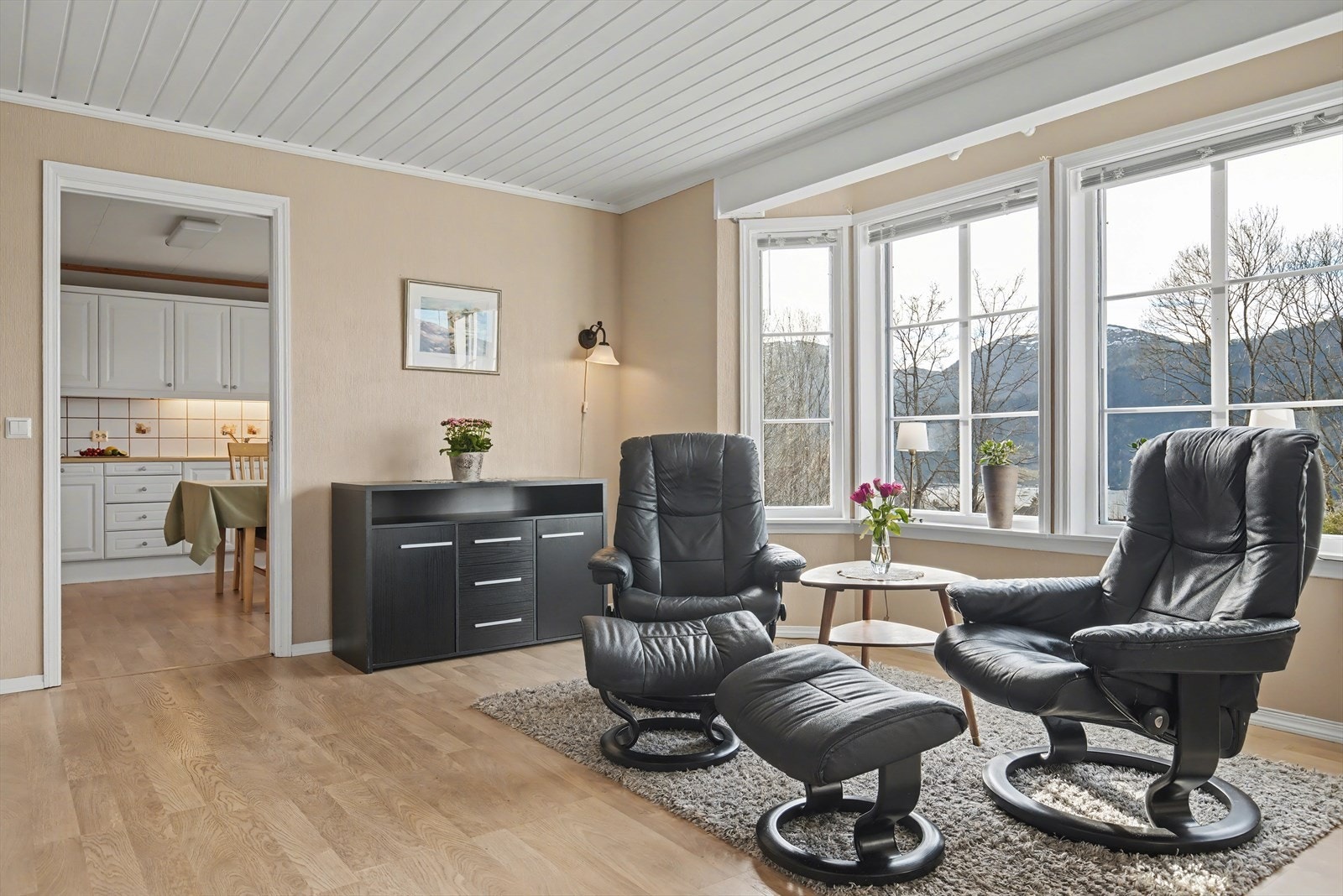 Boligen har en romslig stue med plass for flere sittegrupper Galleribilde