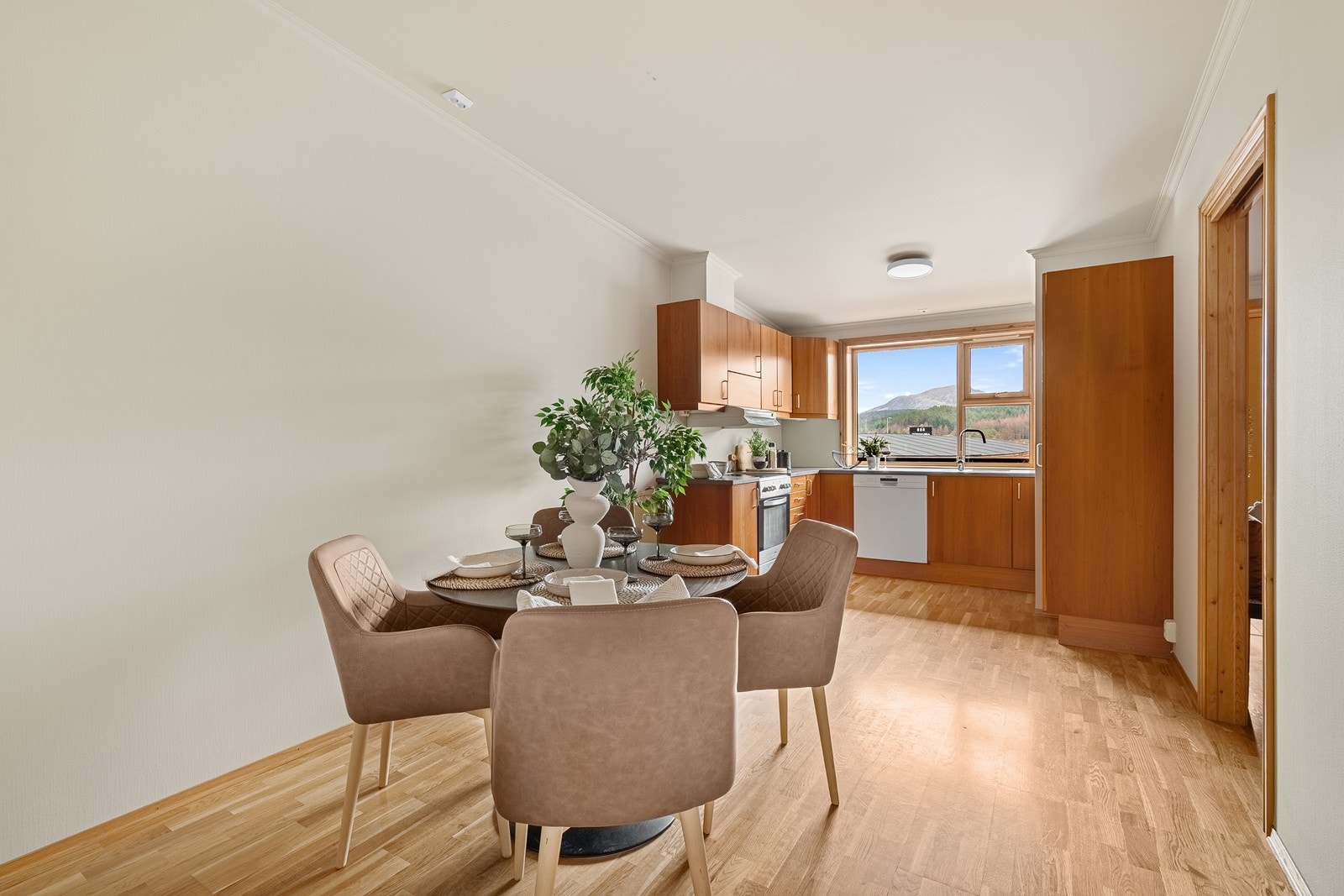 Store vinduer over kjøkkenbenk gir fint lys inn Galleribilde