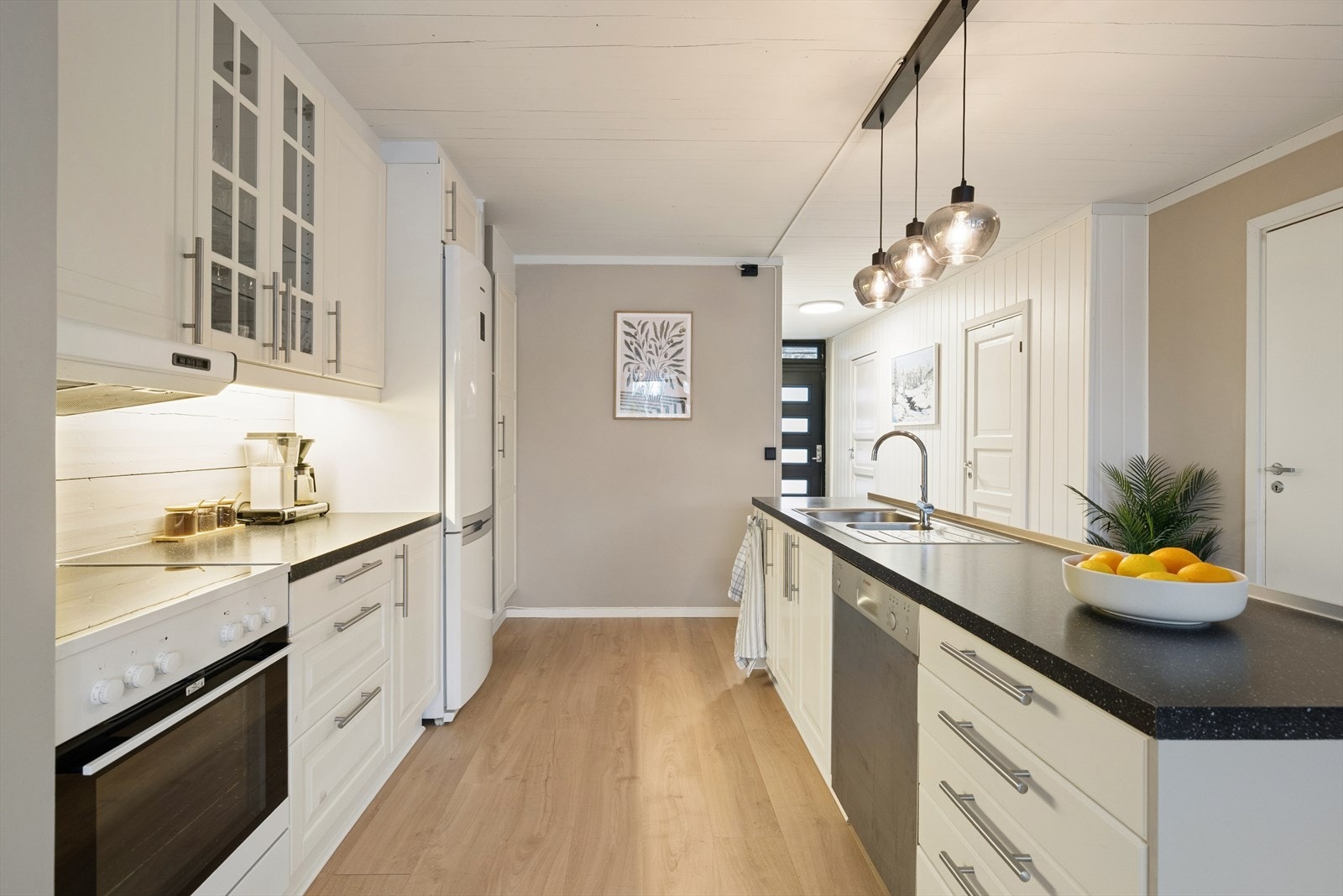 Lyst kjøkken innredet med profilerte fronter og benkeplate av laminat. Galleribilde