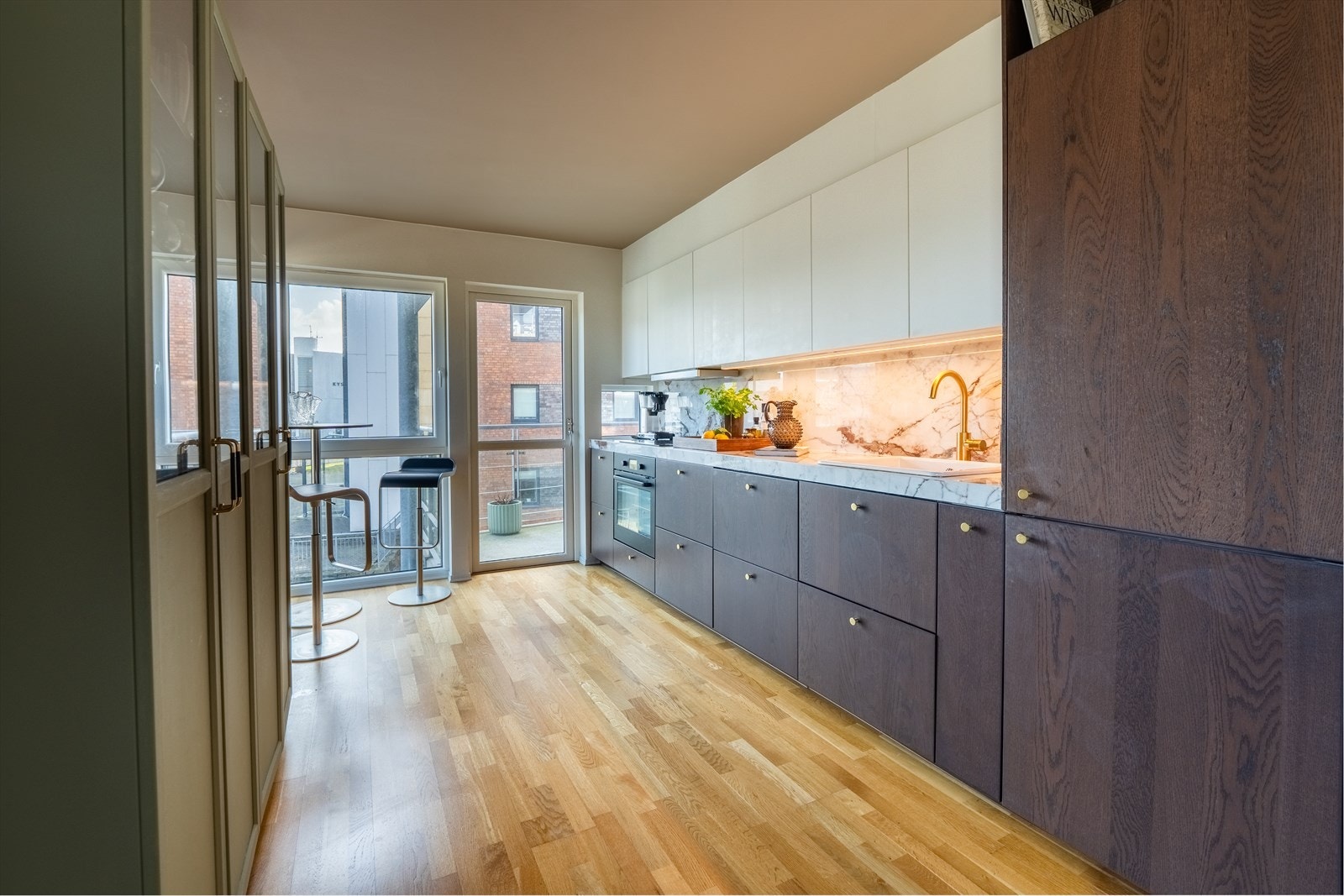 Praktisk og moderne kjøkken med stilige fronter og benkeplate i keramiske fliser (marmor). Galleribilde