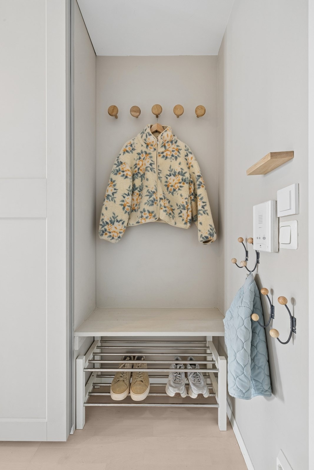 En praktisk nisje ved inngangen med plass til sko og yttertøy. Bygget har dørcalling. Galleribilde