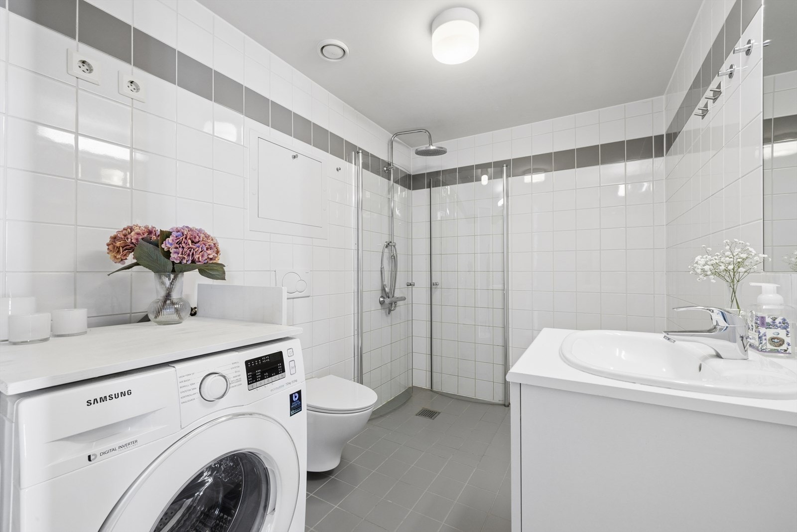 Flislagt bad med varmekabler i gulvet og opplegg for vaskemaskin. Galleribilde