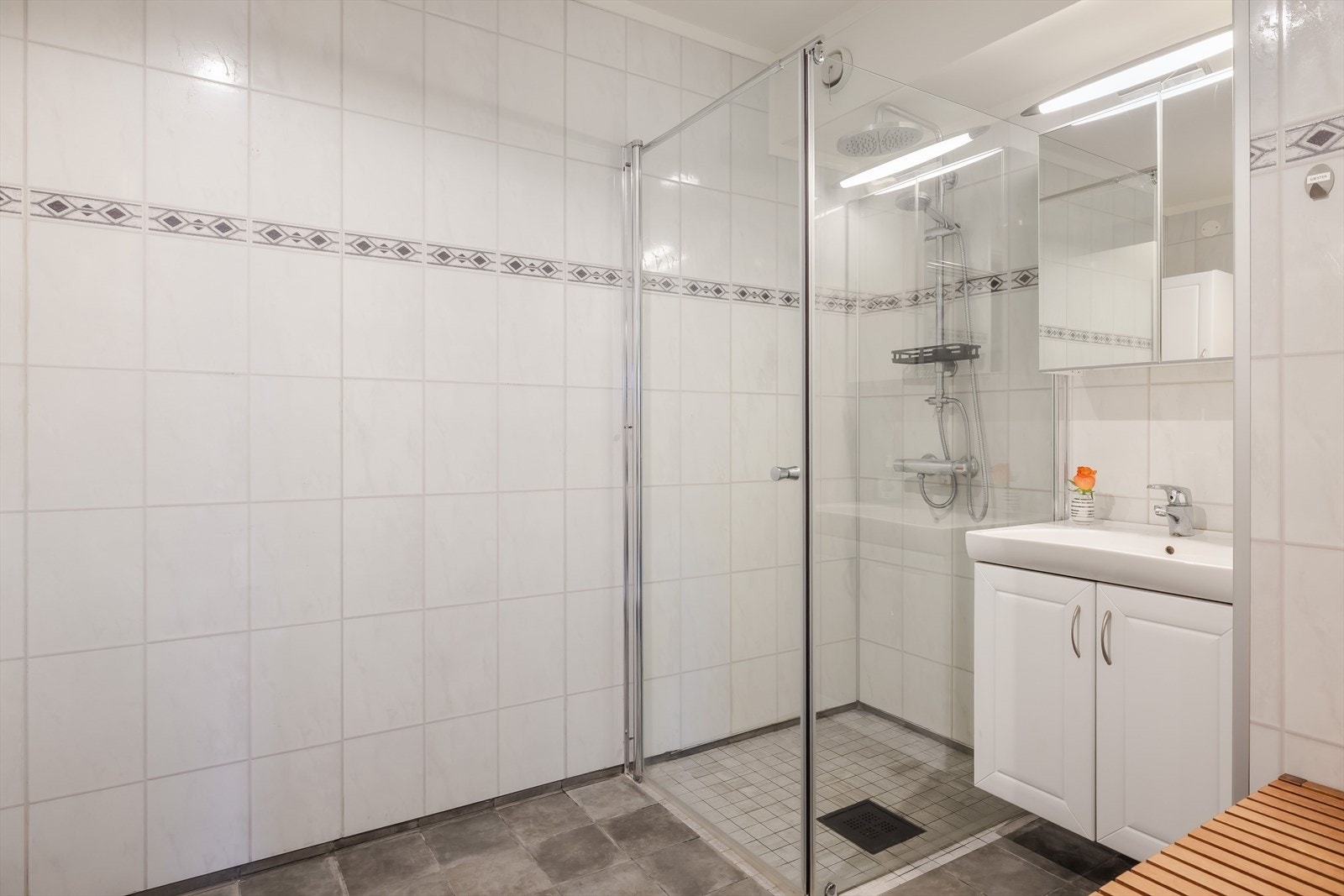 Bad med våtromsplater på veggene og flislagt gulv med elektriske varmekabler. Galleribilde