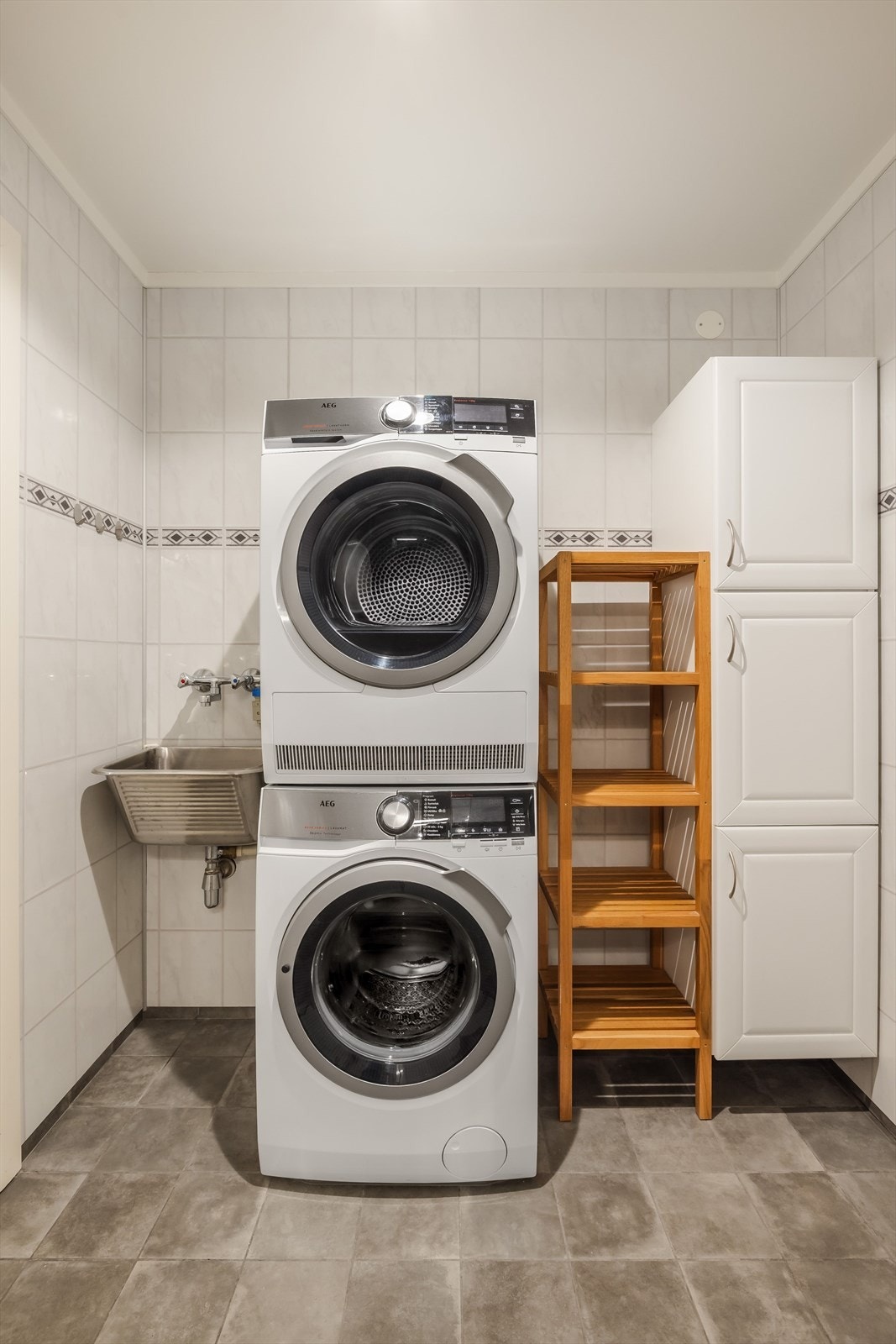 Badet er av god størrelse og har opplegg for vaskemaskin. Det er utslagsvask og veggskap i tillegg. Galleribilde