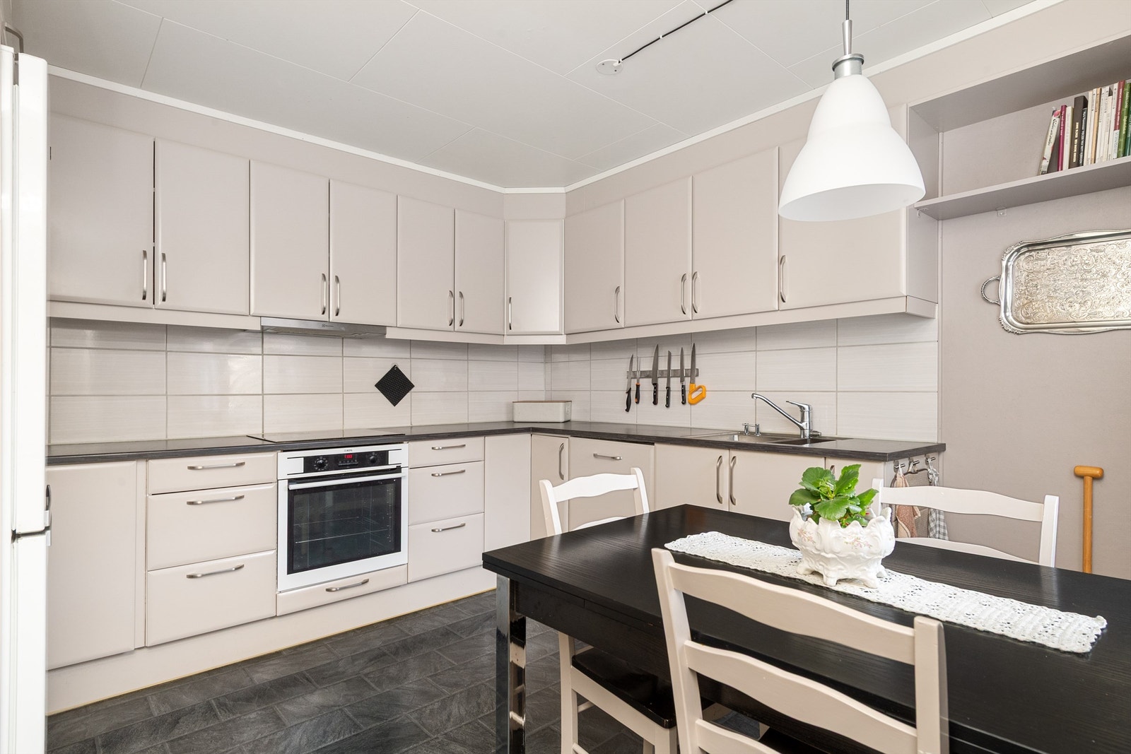 Kjøkkeninnredning med glatte fronter og benkeplate i laminat. Det er integrert oppvaskmaskin, induksjonstopp og stekeovn. Frittstående kjøl-/fryseskap. Galleribilde