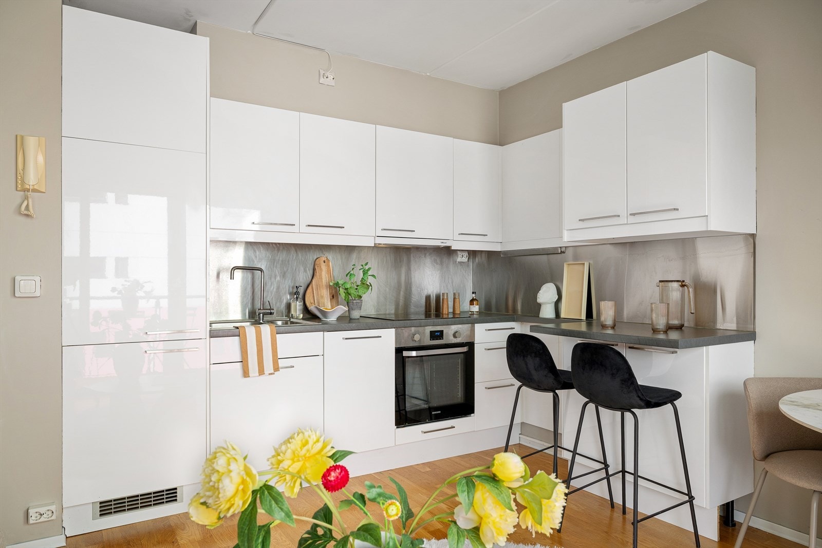 Hvit kjøkkeninnredning med integrerte hvitevarer. Galleribilde