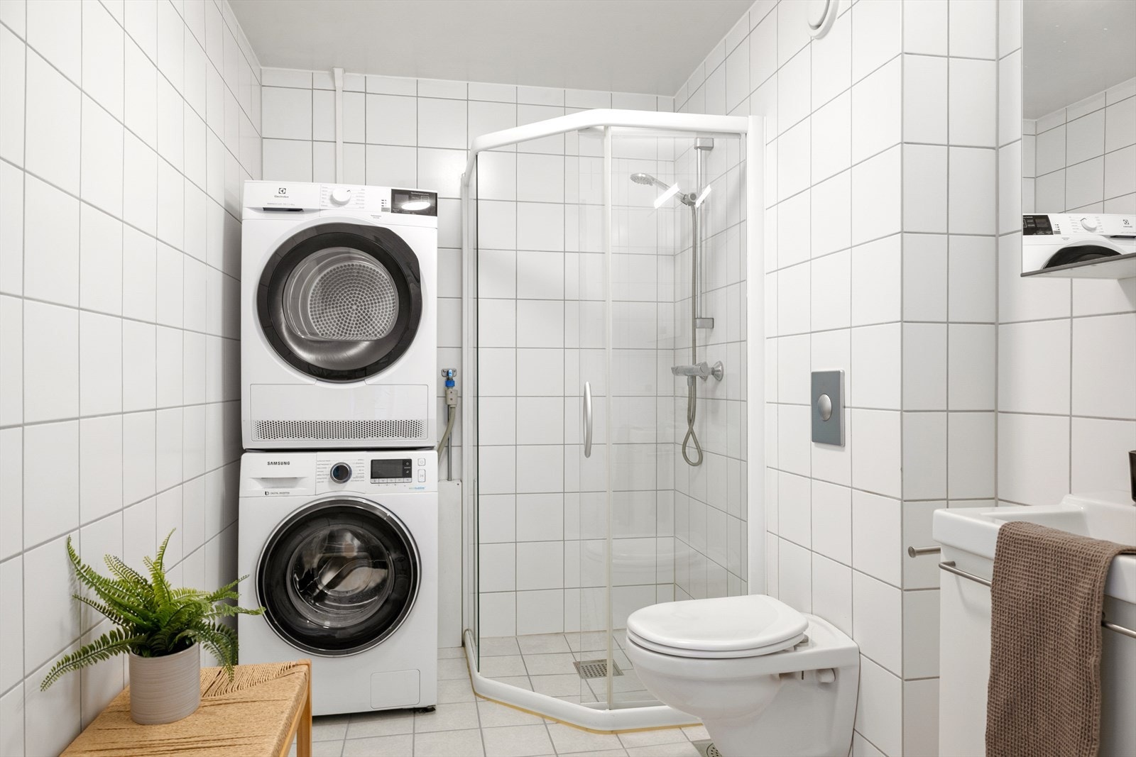 Romslig og moderne bad med mørkegrå fliser på gulv og hvite fliser på vegg. Galleribilde