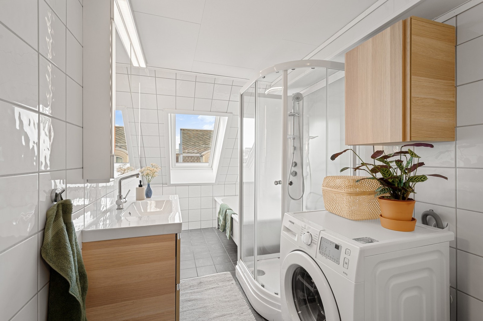 Innbydende bad med flislagte overflater, gode løsninger og både dusj og badekar for økt komfort. Galleribilde