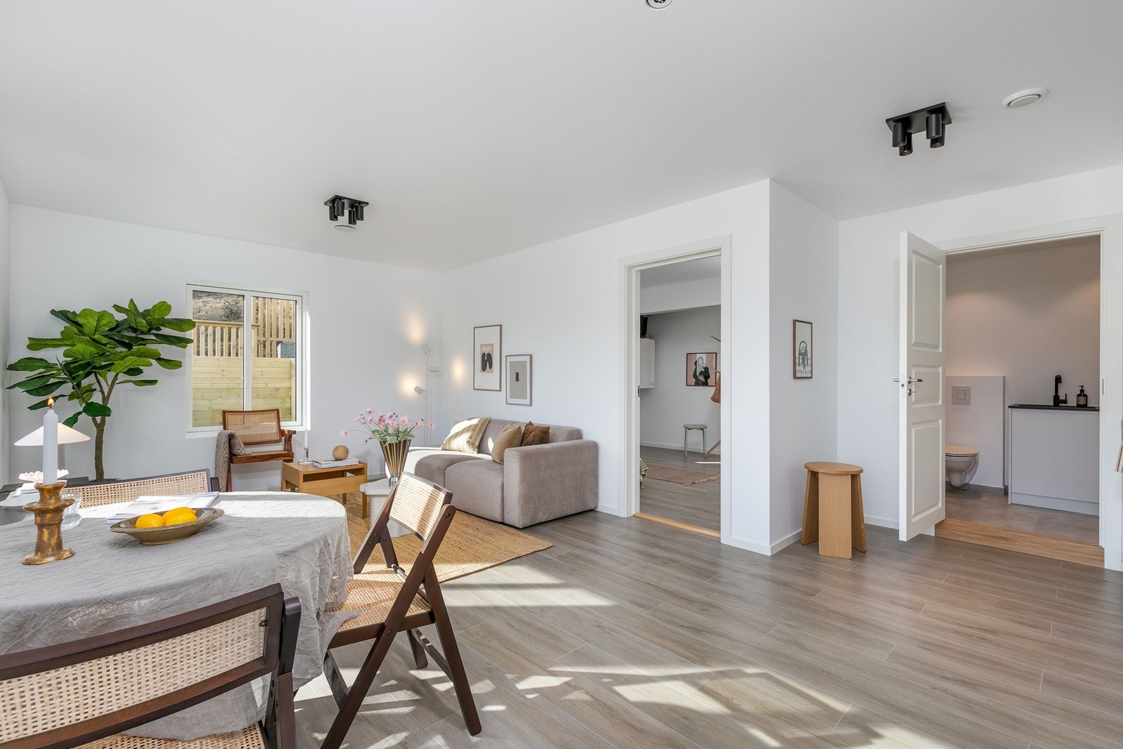 Seksjonert utleiedel: Stuen har lysmalte veggflater og laminat på gulv. Galleribilde