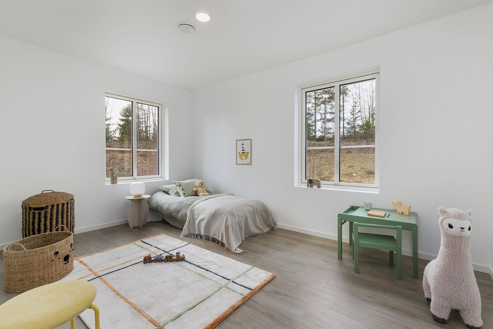 Soverom 2 fremstår som et koselig soverom med malte slette veggflater, laminat på gulv og store vindusflater som slipper inn rikelig med lys. Galleribilde