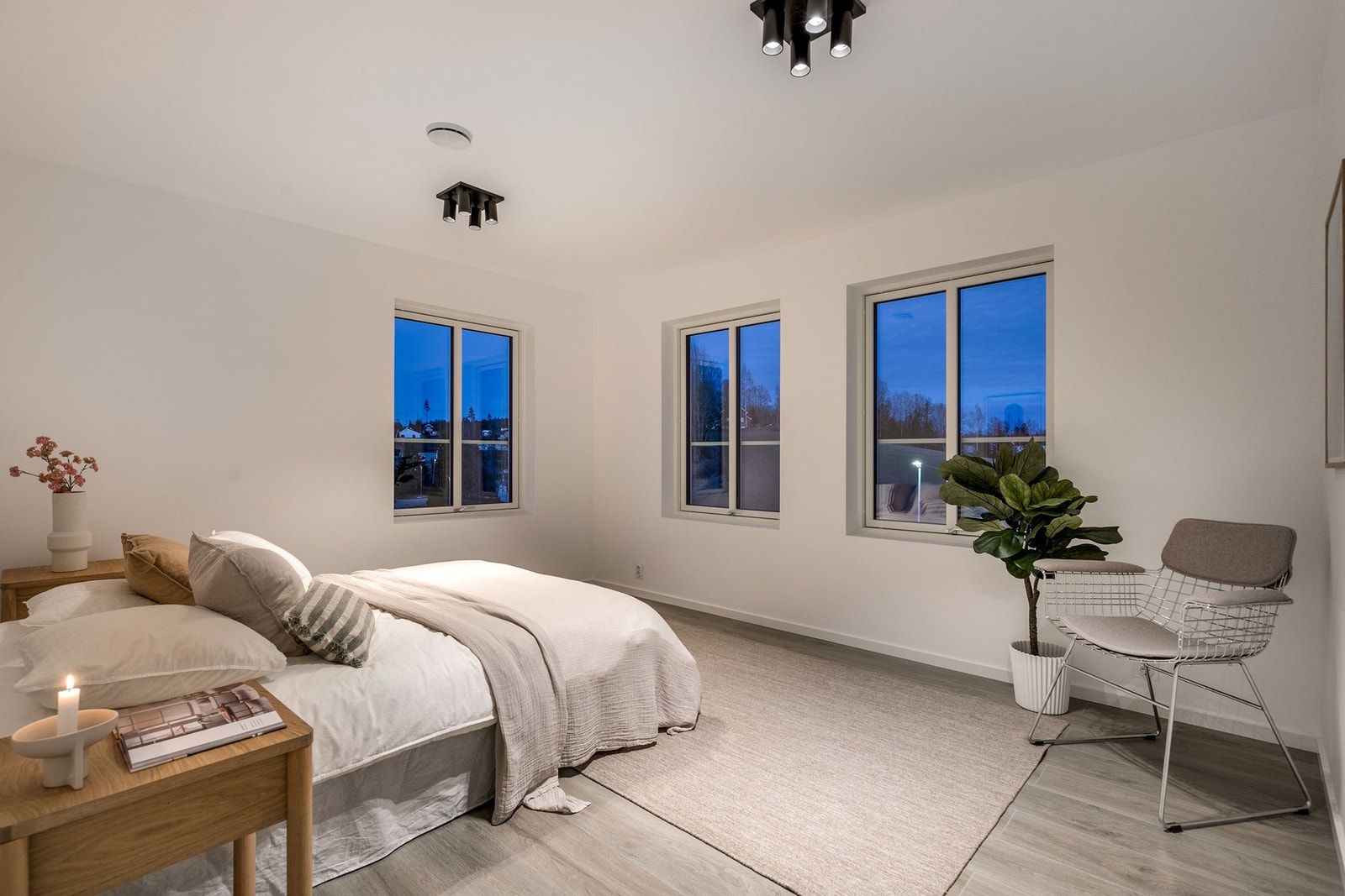 Hovedsoverommet har lysmalte veggflater, laminat på gulv og store vindusflater. Galleribilde
