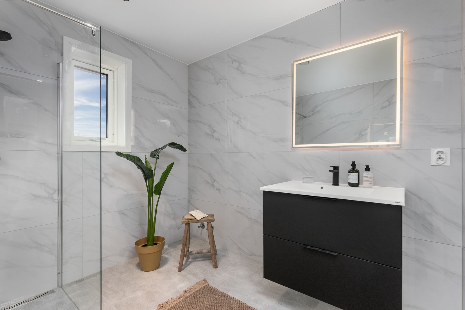 Hovedbadet ligger i en egen suite-avdeling i 2. etasje og har storformatfliser, gulvvarme, servantmøbel, samt speil med belysning. Galleribilde