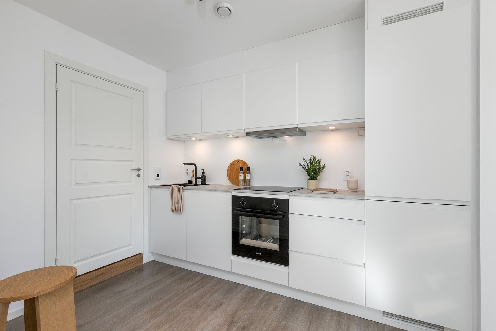 Seksjonert utleiedel: Moderne kjøkken. Av hvitevarer medfølger integrert platetopp, komfyr, oppvaskmaskin, samt kombinert kjøle-/ og fryseskap. Galleribilde