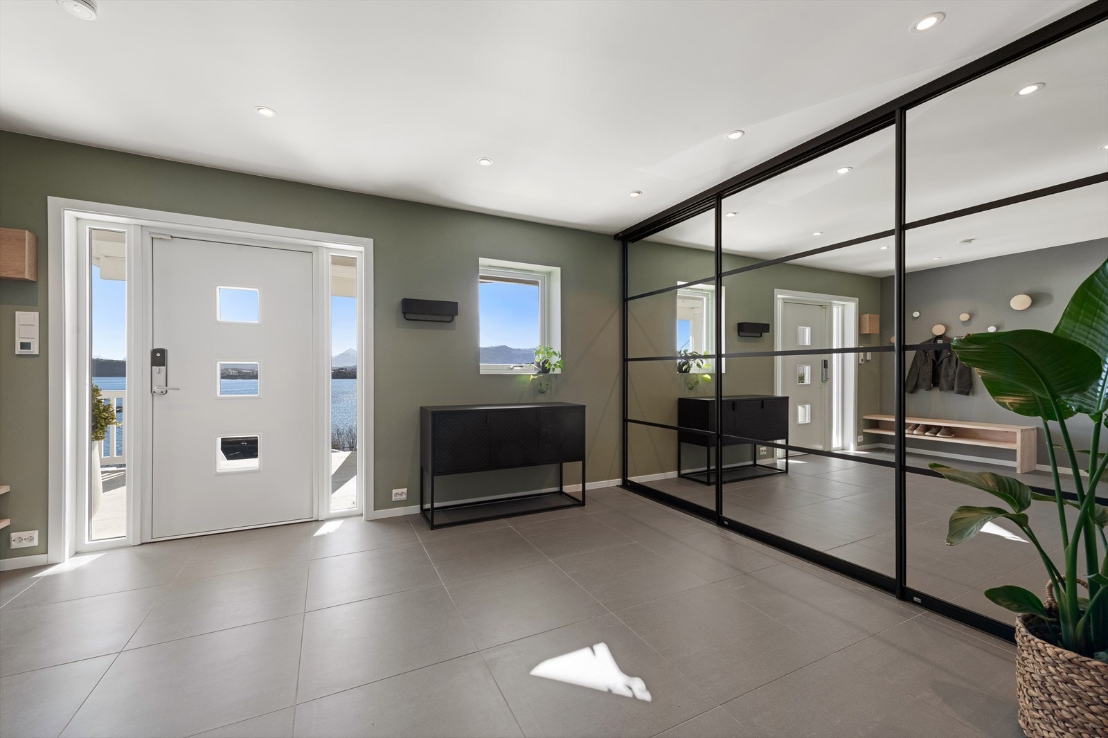 Stor og romslig flislagt hall i inngangsparti. Stor skyvedørsgarderobe med rikelig lagringsplass. Galleribilde