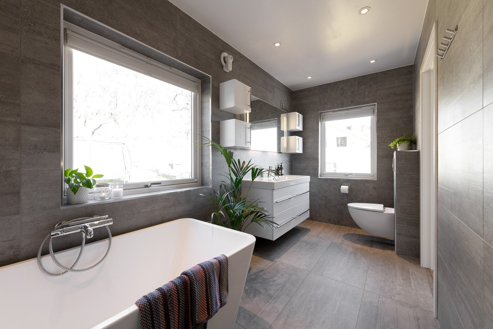 Stort helfliset bad i hovedetasje, med både badekar, dusjnisje og rikelig med innredning. Store vinduer gir mye deilig dagslys og mulighet for friskluft. Galleribilde