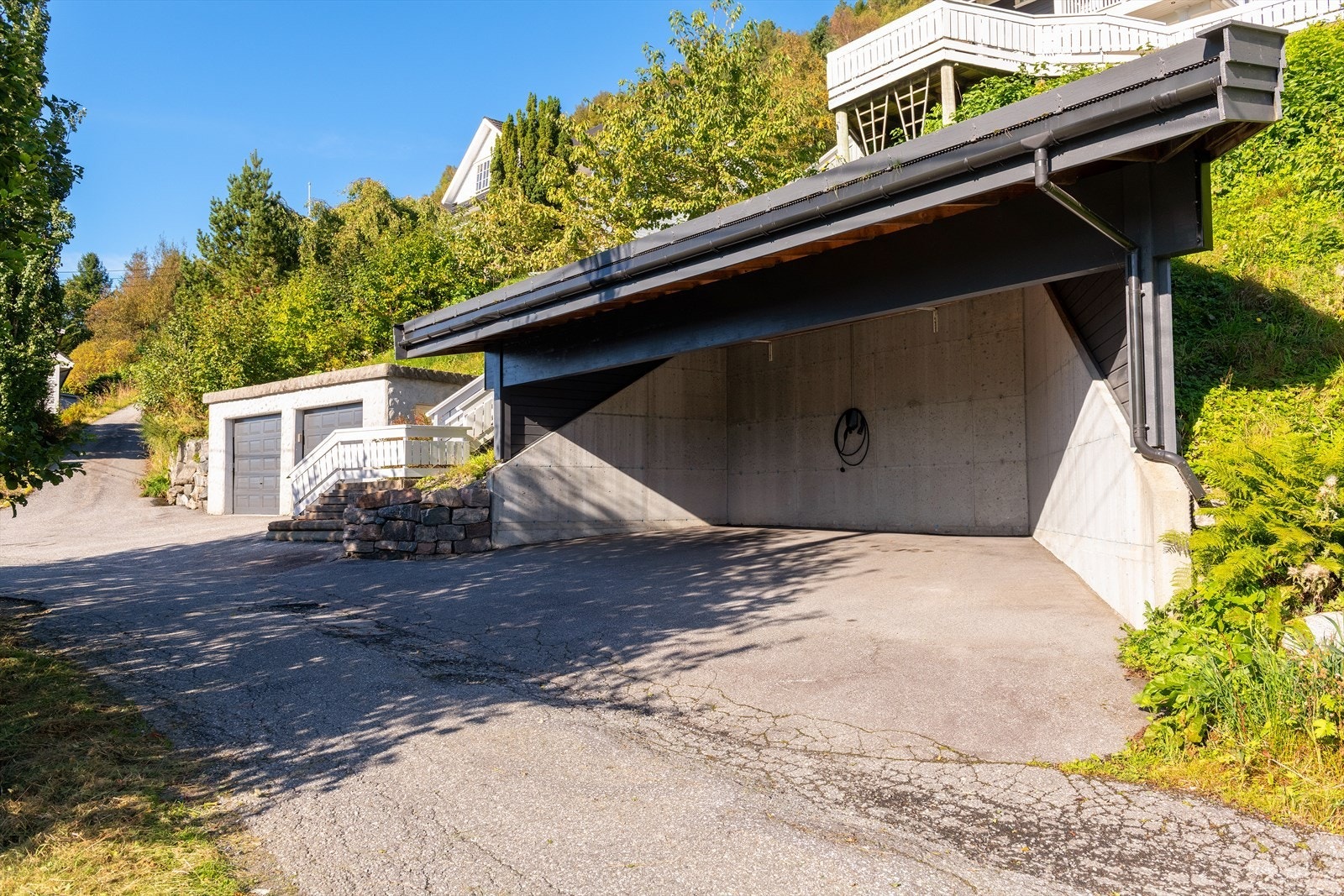 Dobbel garasje og stor carport. I carport er det montert elbil-lader. Galleribilde