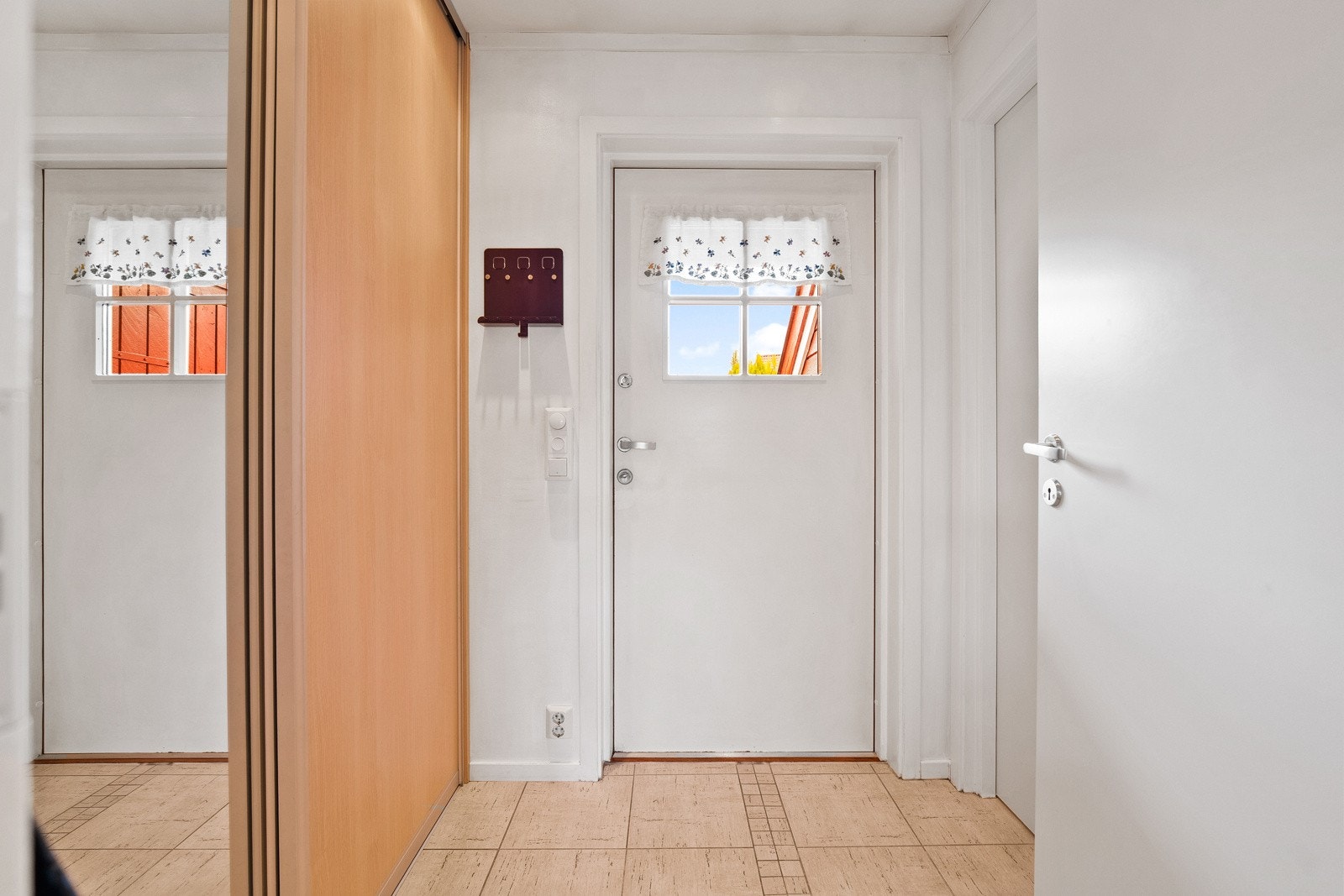 Entré. Garderobeløsninger langs den ene veggen. Inngang til tolaett til høyre i bildet. Galleribilde