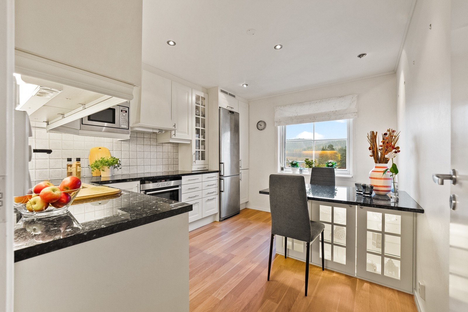 Kjøkkenet fremstår som lyst og innbydende med profilerte fronter og en harmonisk fargepalet. Innredningen er godt planlagt med både over og underskap, noe som gir svært gode oppbevaringsmuligheter og effektiv utnyttelse av plassen. Galleribilde