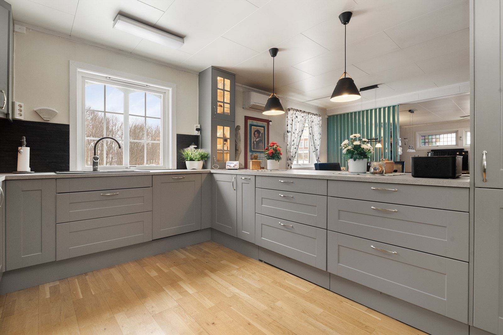 Kjøkken har profilert Norema innredning fra 2018 og laminert benkeplate med dekorativ skifer-/natursteins plater som sprutbeskyttelse. Galleribilde