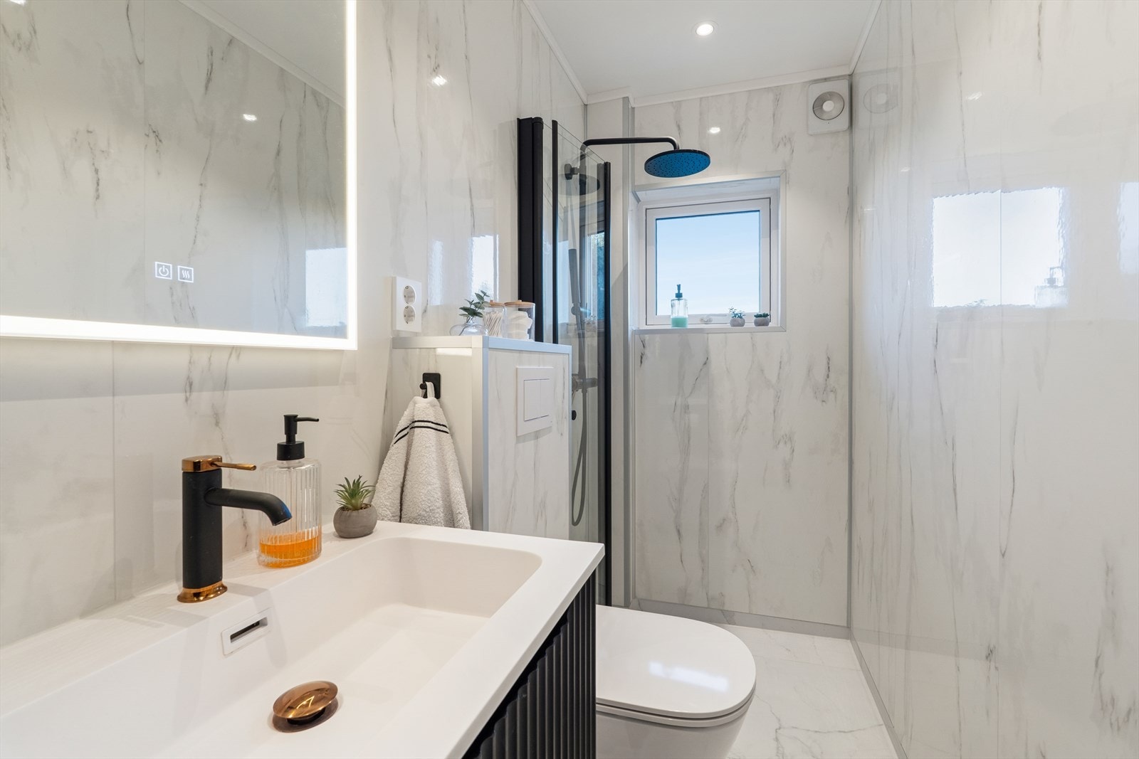 Badet er rennovert i 2024, her finner du vegghengt toalett, dusjnisje og innredning i tidsriktige farger. Galleribilde