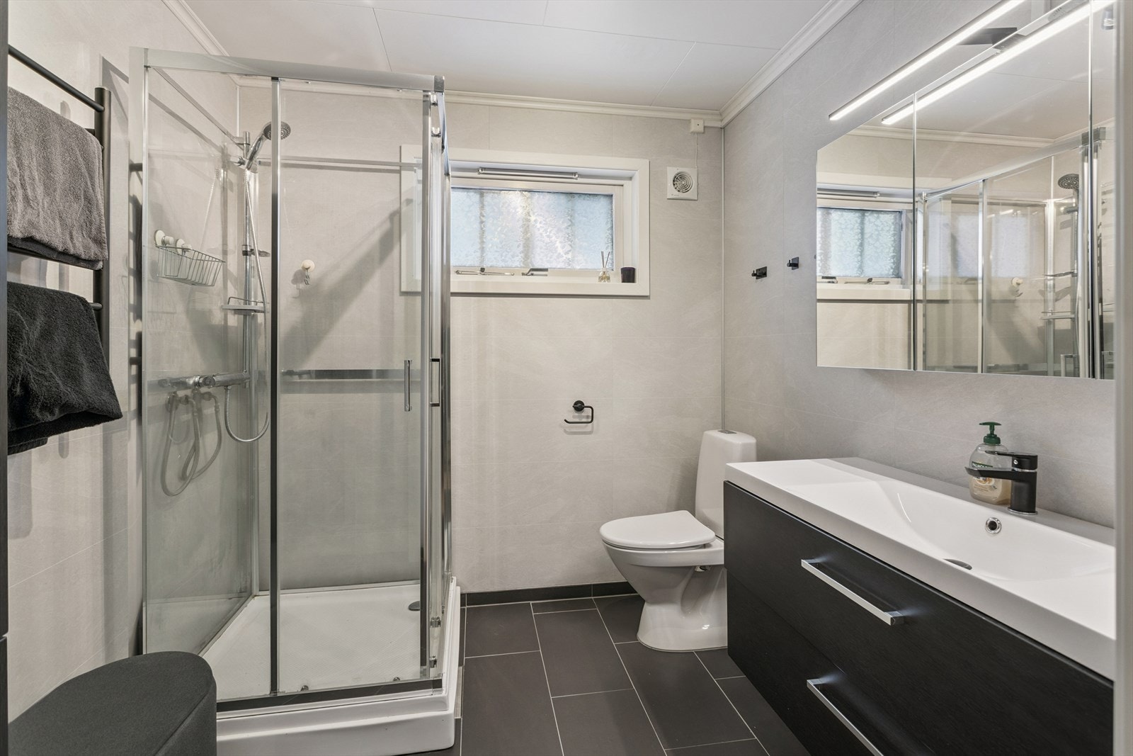 Badet i første etasje ble pusset opp i 2020 med baderomsplater og dusjkabinett. Galleribilde