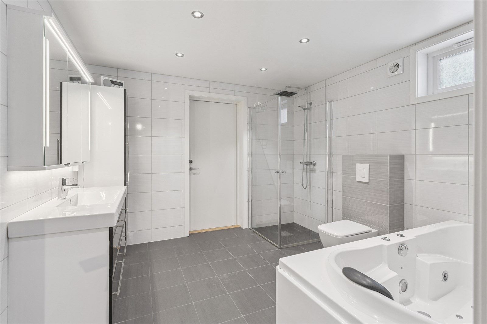 Kjellerbadet er utstyrt med både dusjhjørne og badekar, samt downlights i taket. Galleribilde