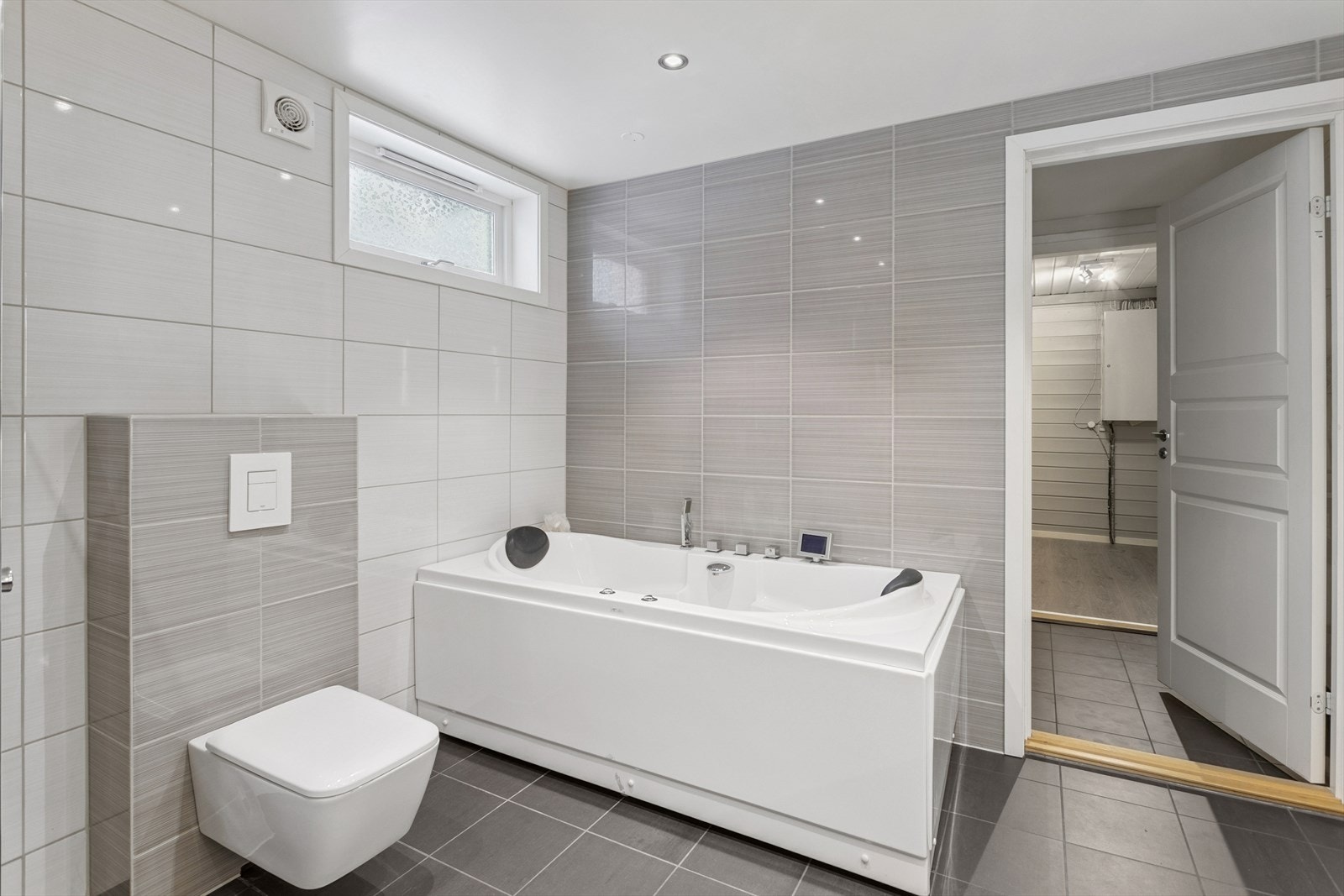 Badet har vegghengt toalett og direkte adkomst til det praktiske vaskerommet. Galleribilde