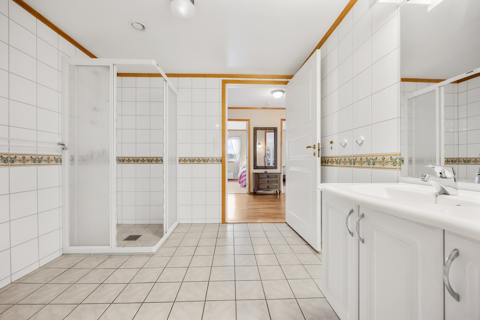 Badet er helfliset og har innredning bestående av servant over hvitt servantskap, matchende overskap og speil med tilhørende lys. Galleribilde