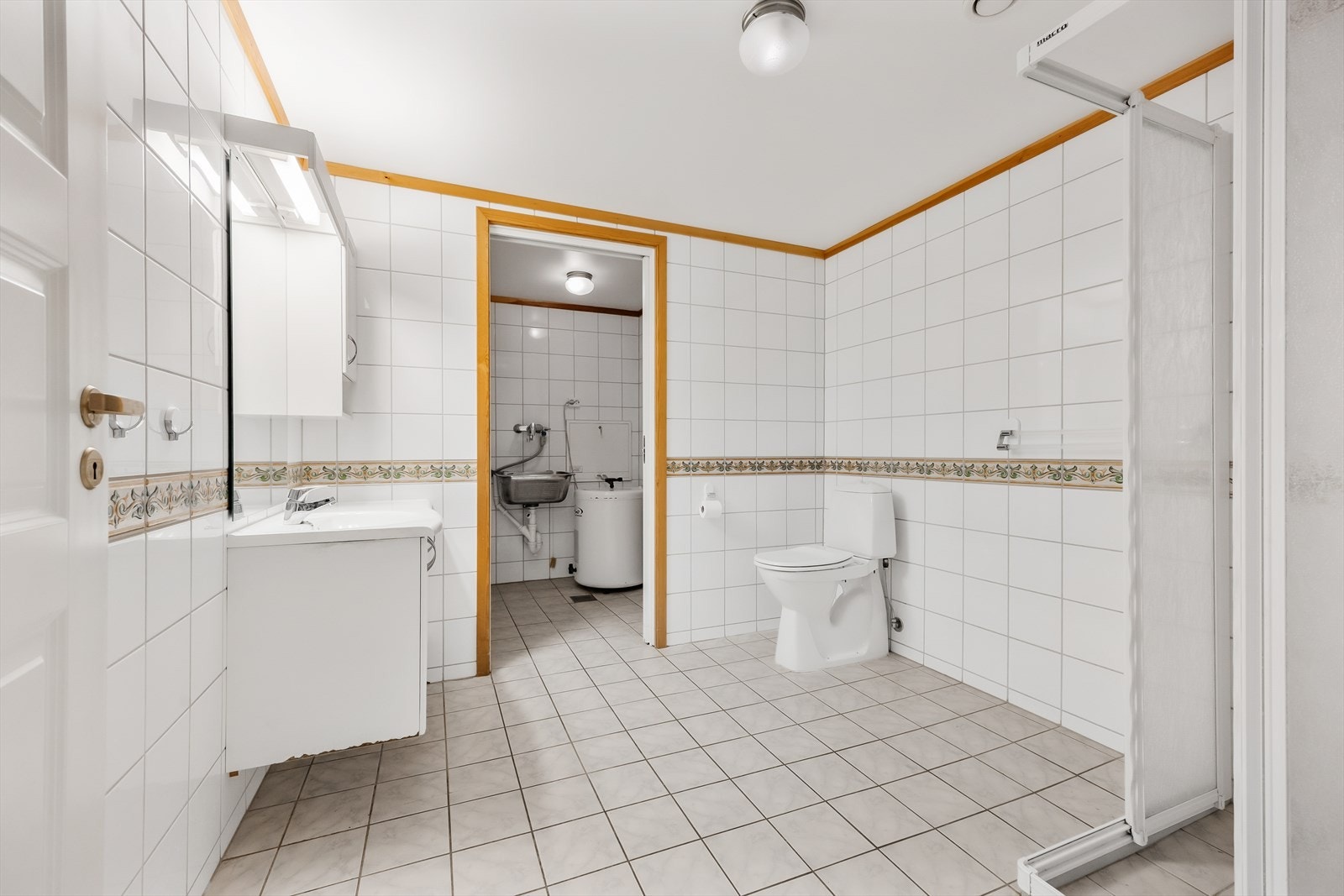 Leiligheten har separat vaskerom innenfor badet - rommene skilles av en praktisk skyvedør. Galleribilde