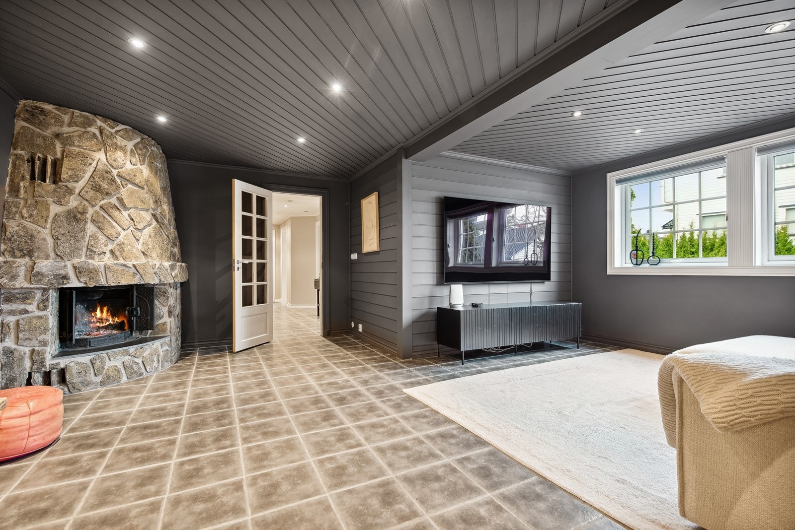 Koselig peis med naturstein i kjellerstuen. Rommet egner seg godt for både småbarn og ungdom, og har enkel adkomst fra entréen. Galleribilde