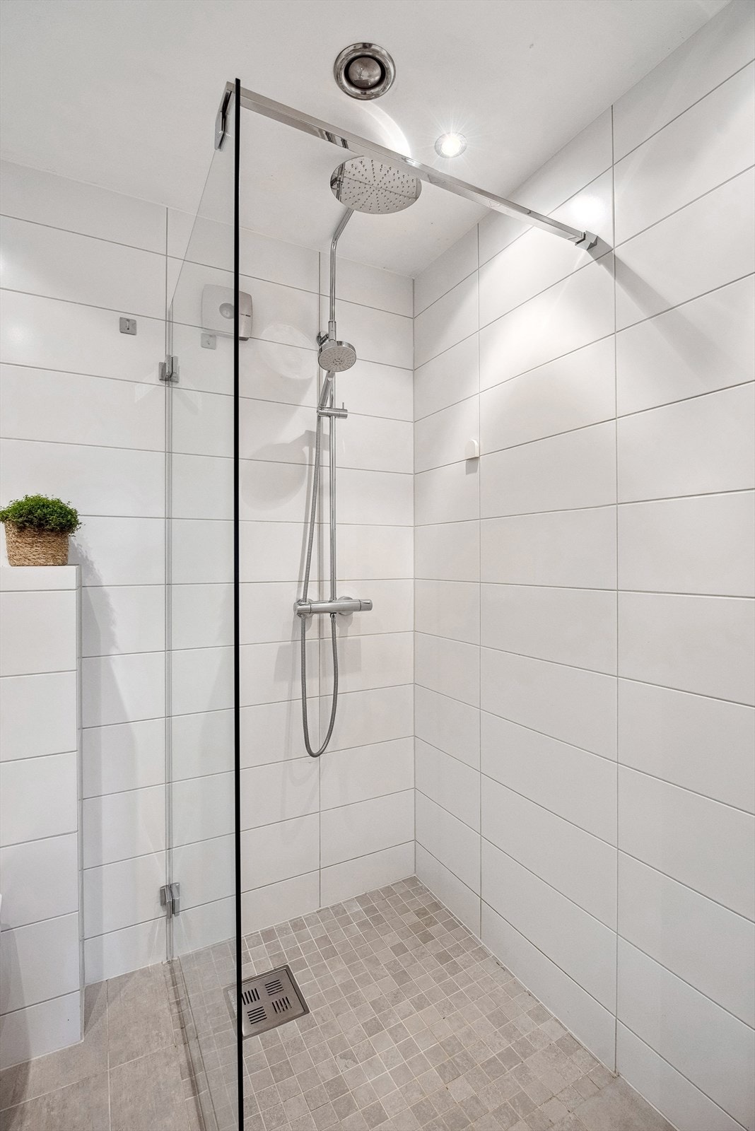 Dusjsonen er romslig og praktisk utformet med glassvegg, takdusj og hånddusj, og fremstår som en innbydende del av badet. Galleribilde